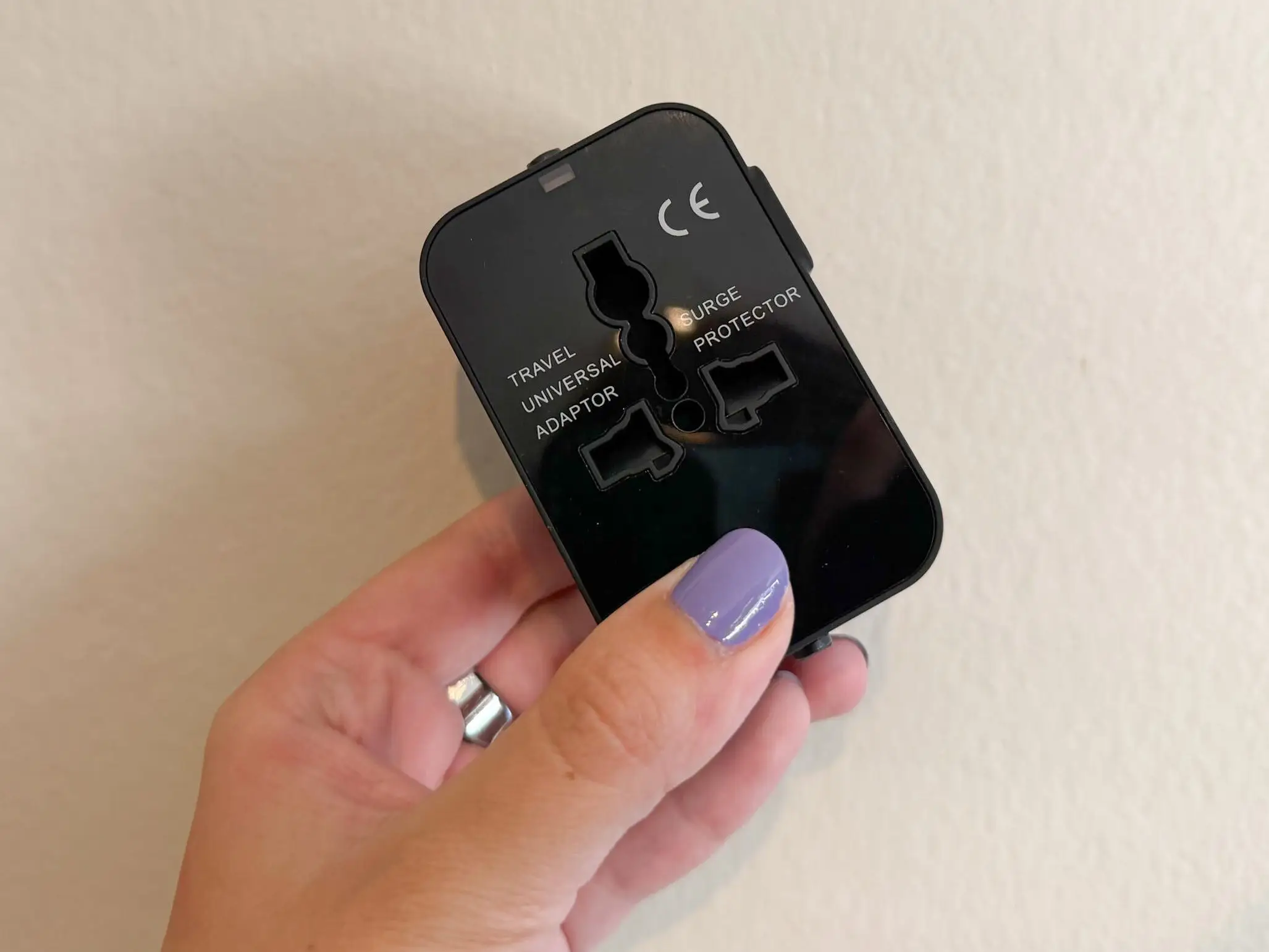 The writer is holding an all-in-one worldwide adapter.