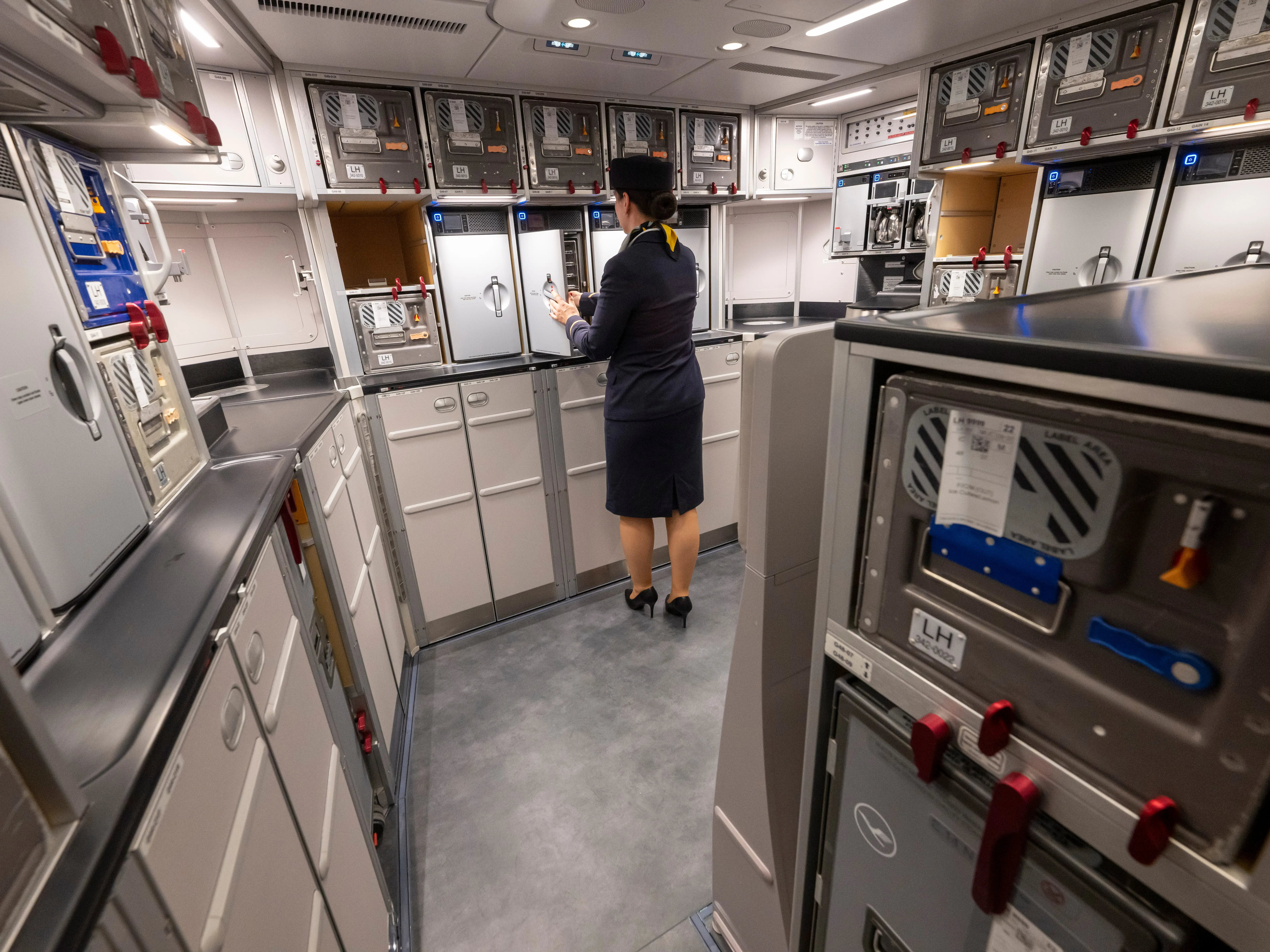 A flight attendant in an airplane galley.