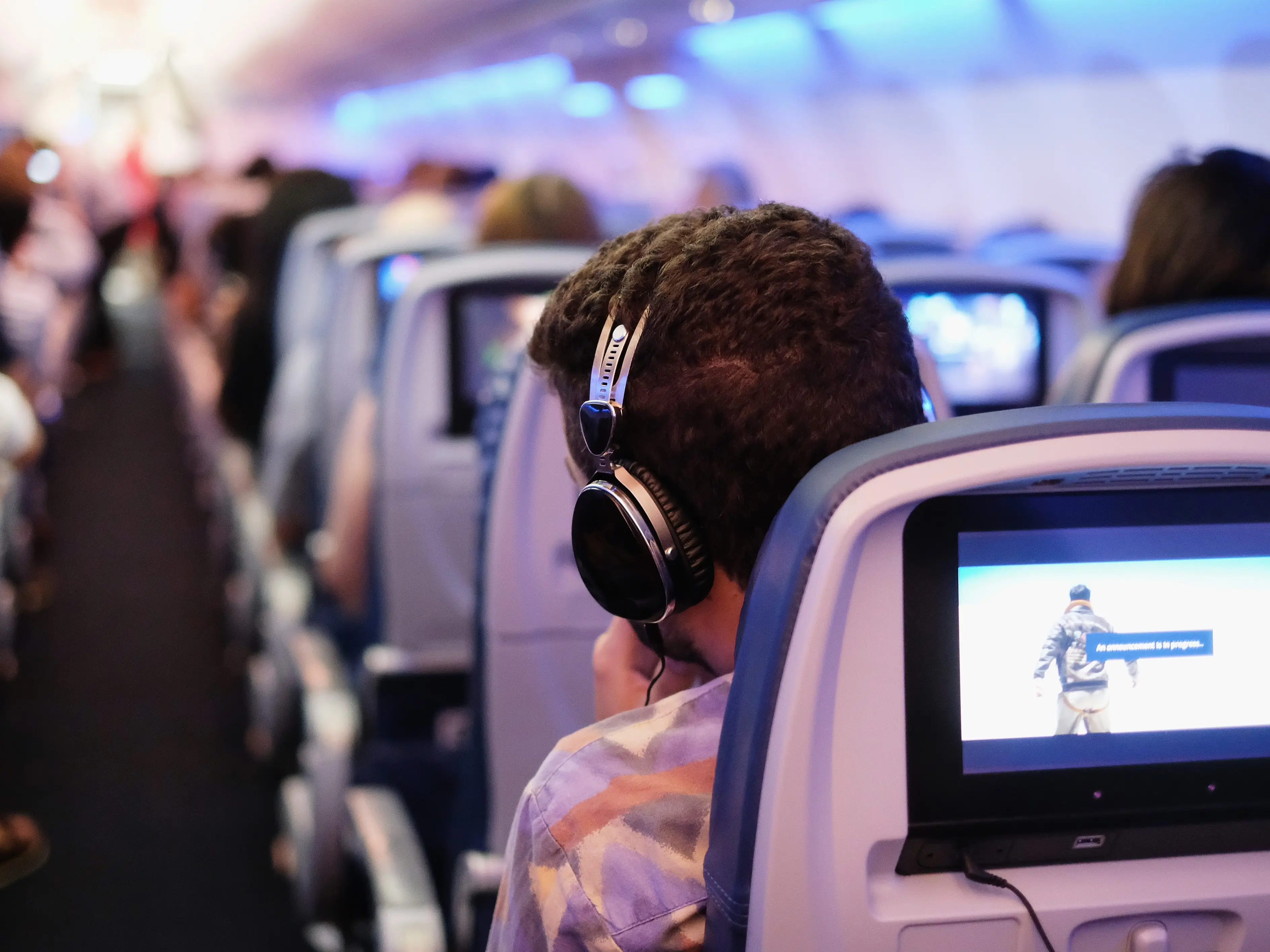 Person wearing headphones on a plane.