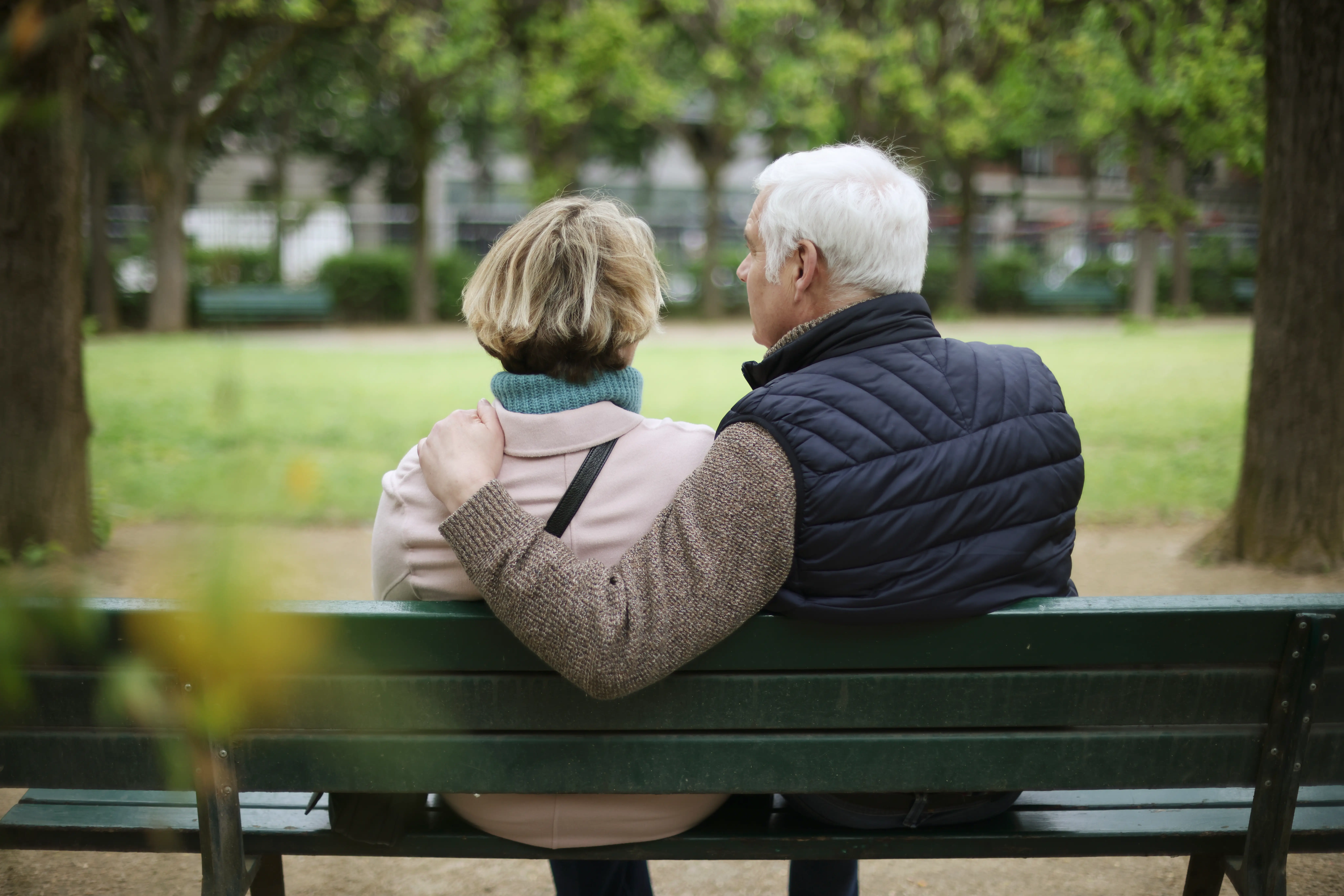 A couple sitting on a park bench in retirement