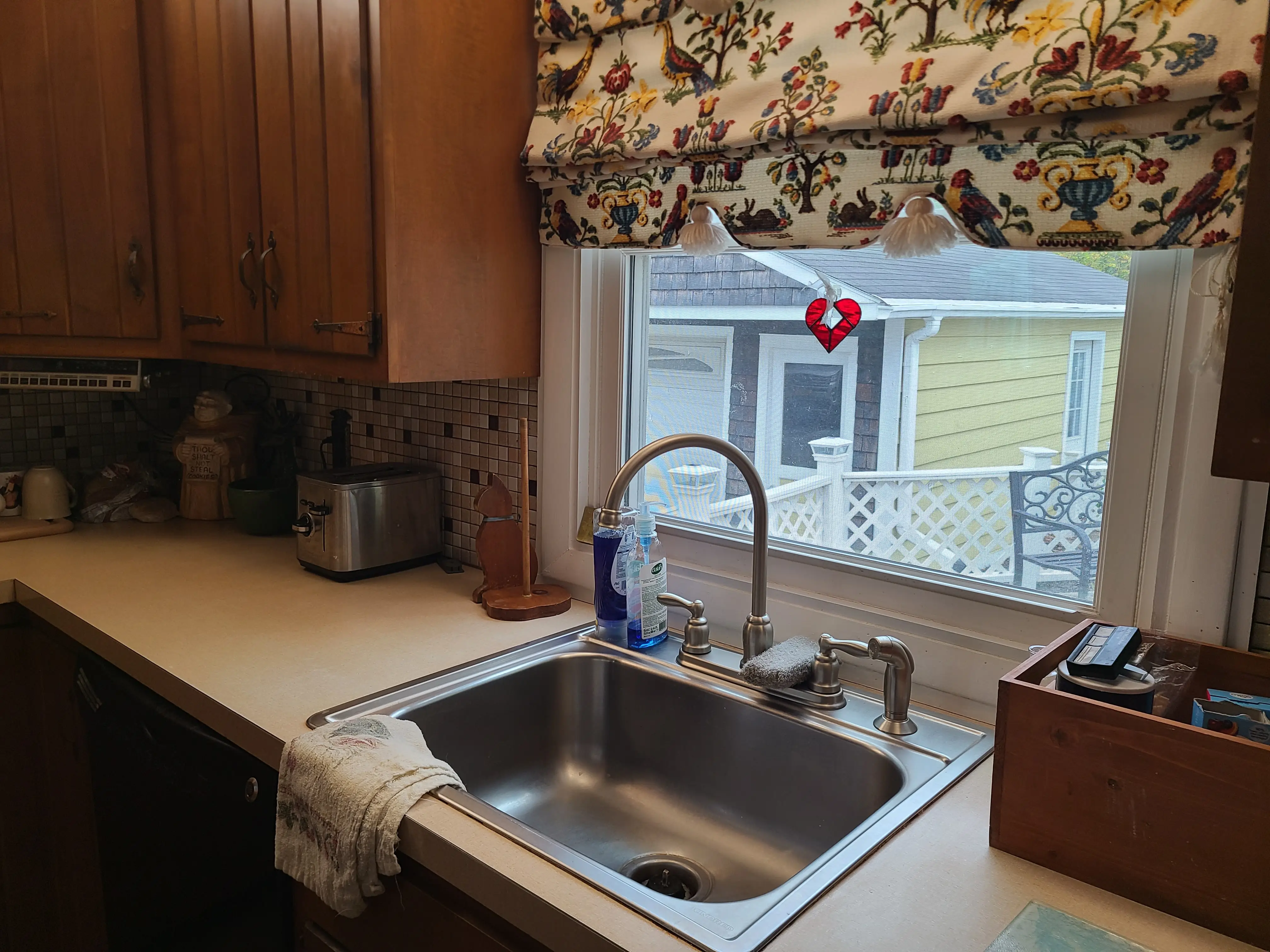 Clean stainless-steel sink below window in kitchen