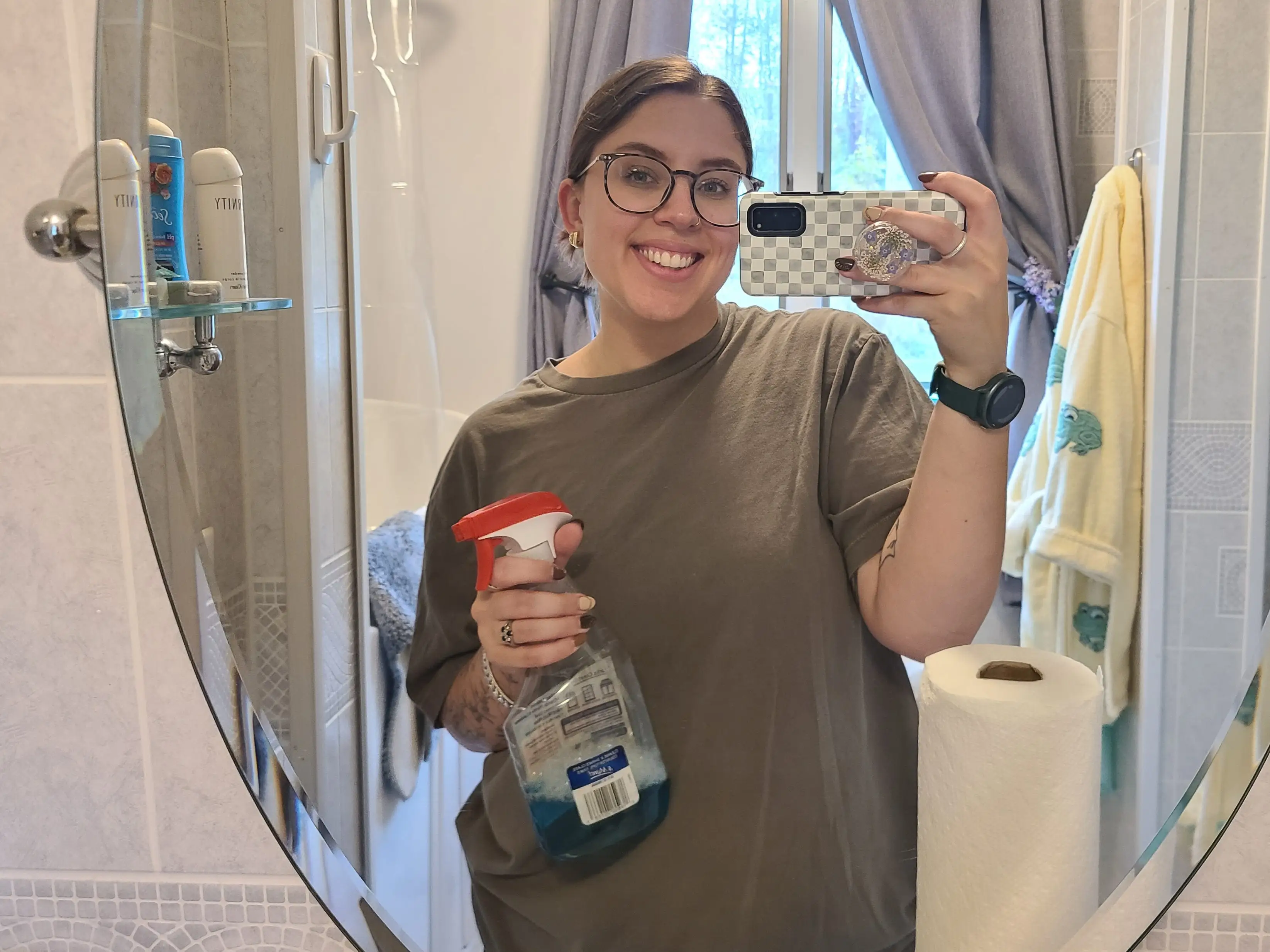 Woman smiling in mirror selfie holding a cleane