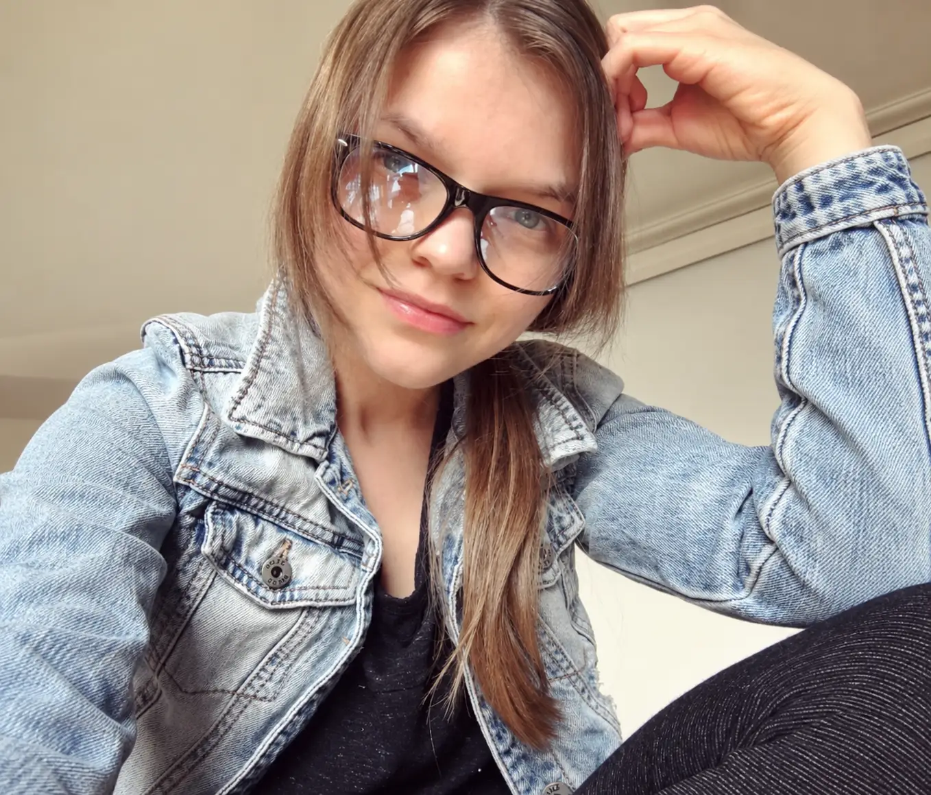 a woman poses in a denim jacket