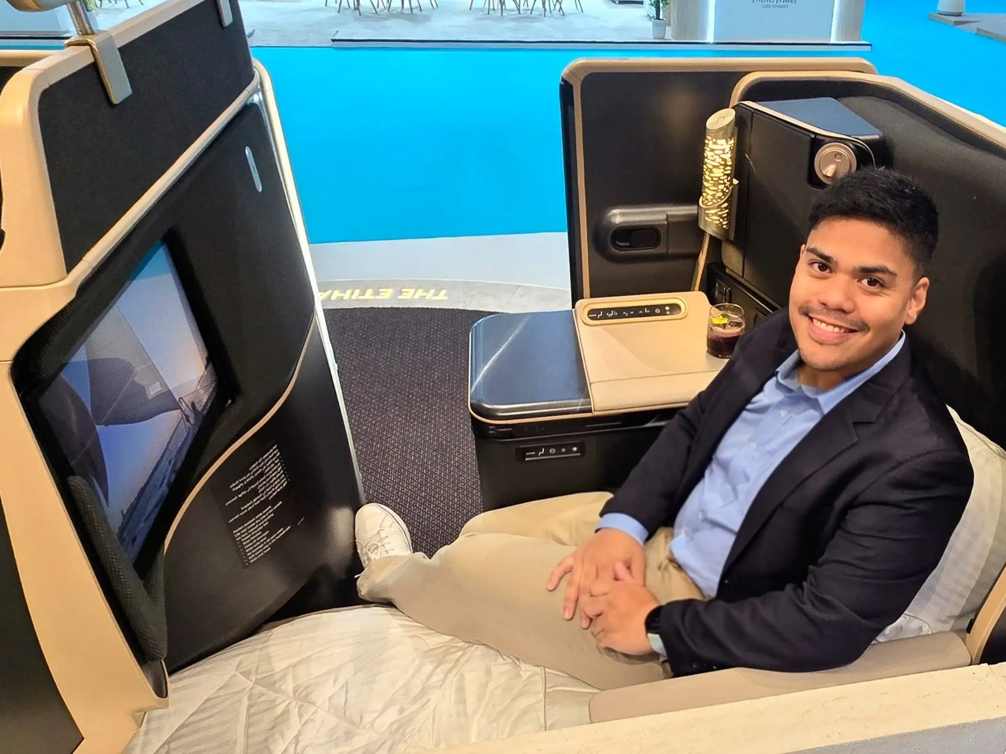 The author sitting in Etihad's business class mockup, which is beige and brown.