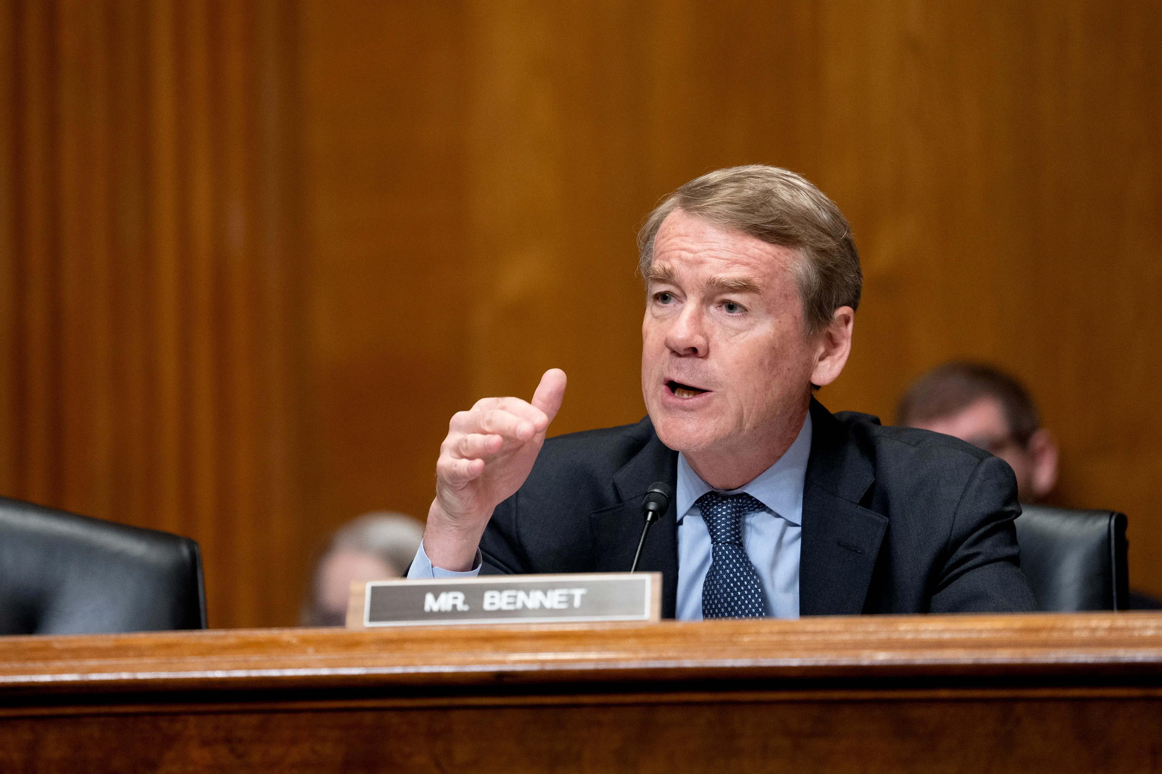A man in a suit speaks.