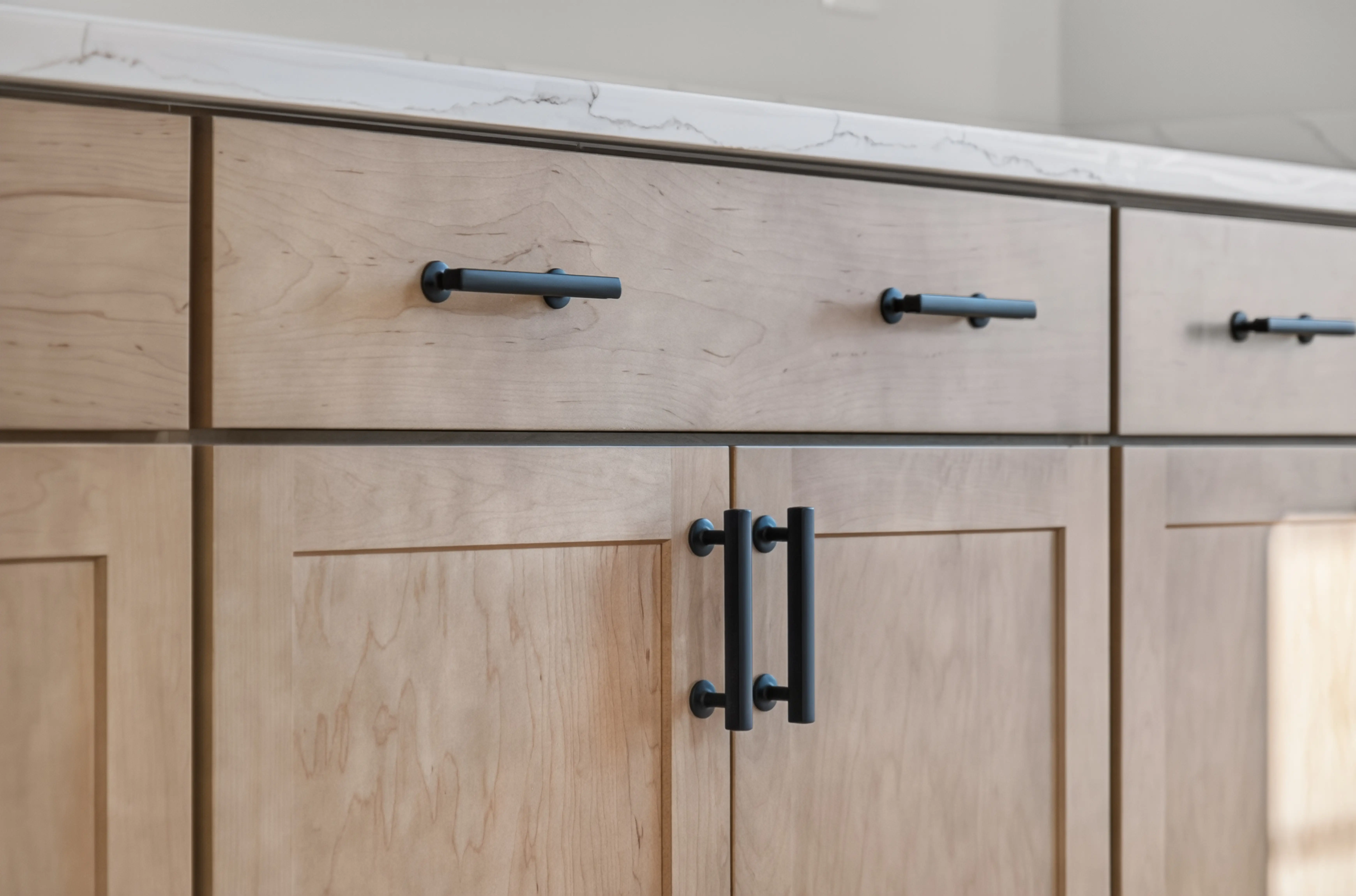 Light wood cabinet with black hardware