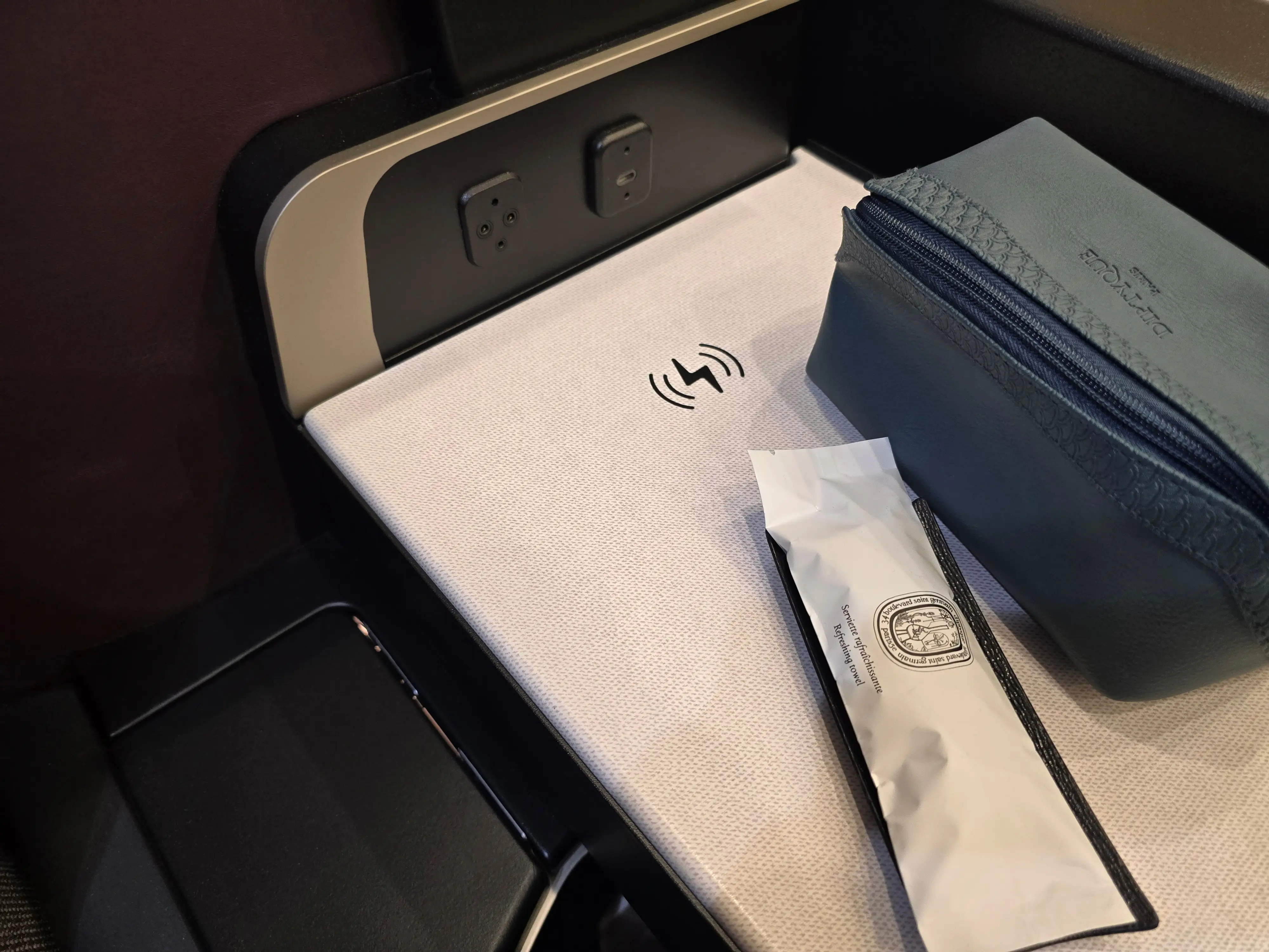 The blue amenity kit on the wireless charging in the new Qsuite.