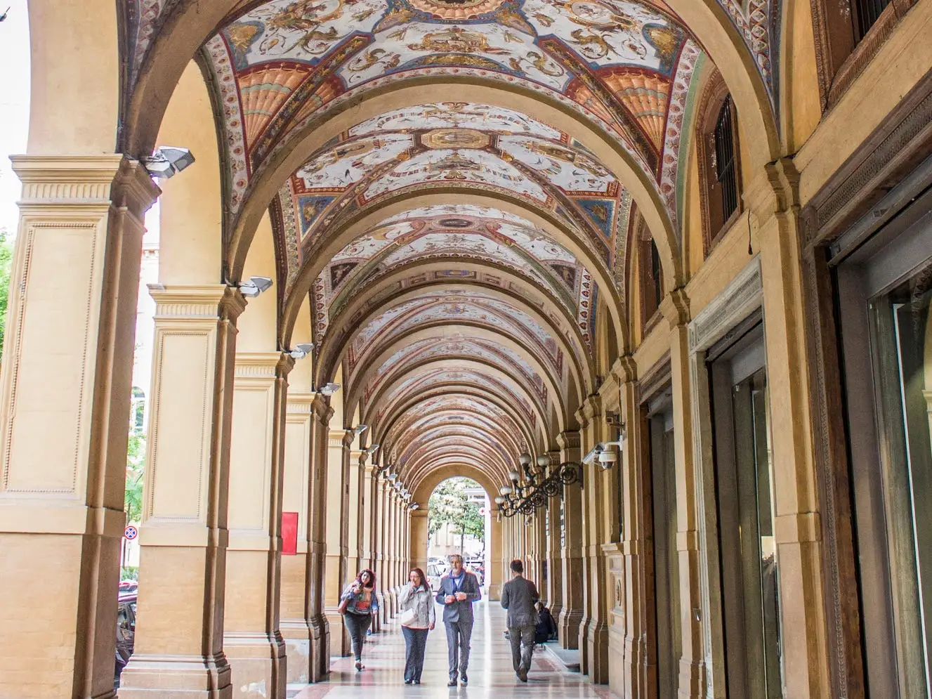 Ornate covered arcade featuring portico archways in Bologna, Italy.