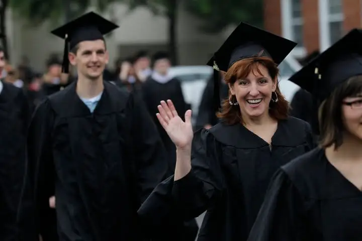 the author smiling and waving at graduation