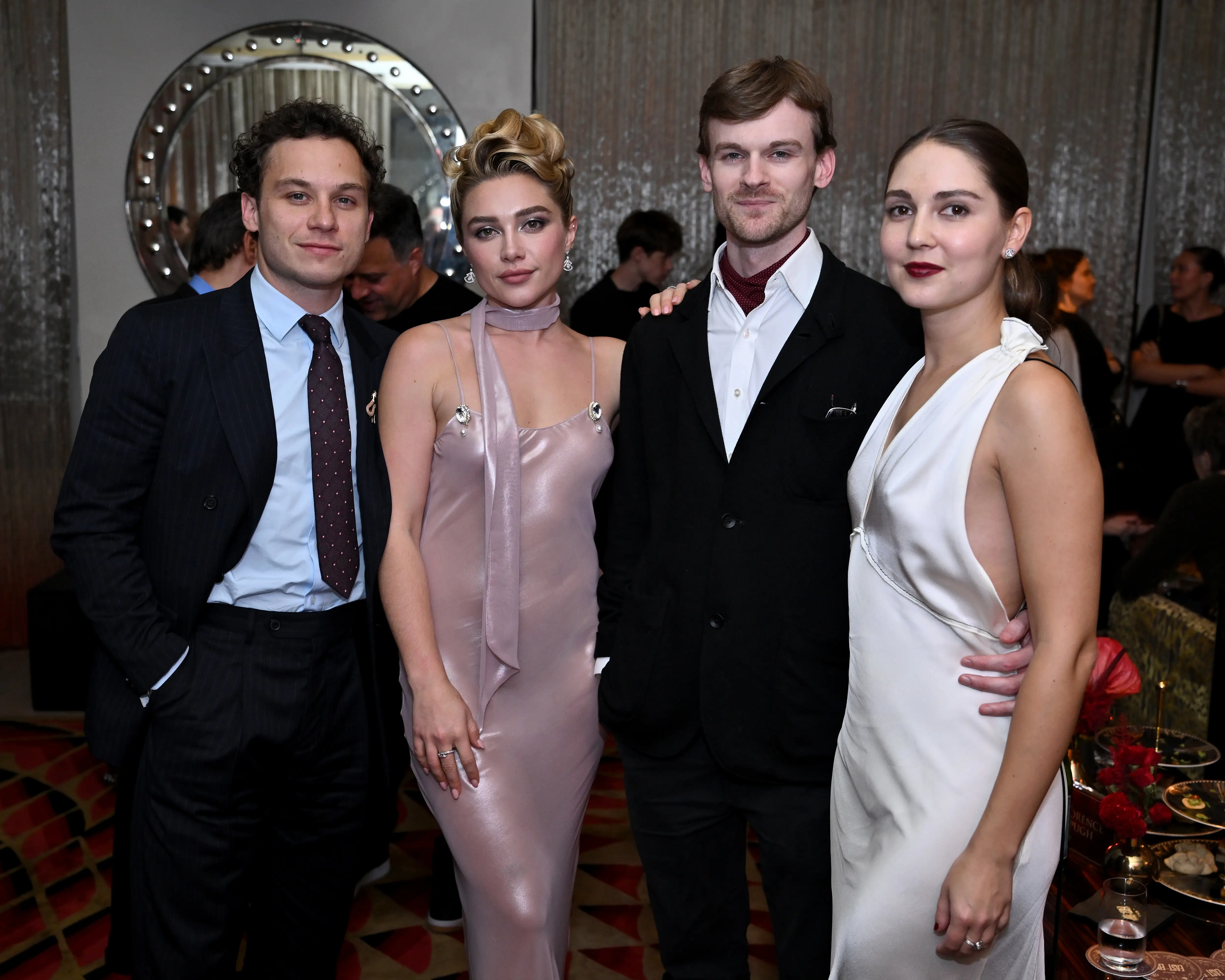 Florence Pugh and three formally dressed attendees pose together at an indoor event reception.