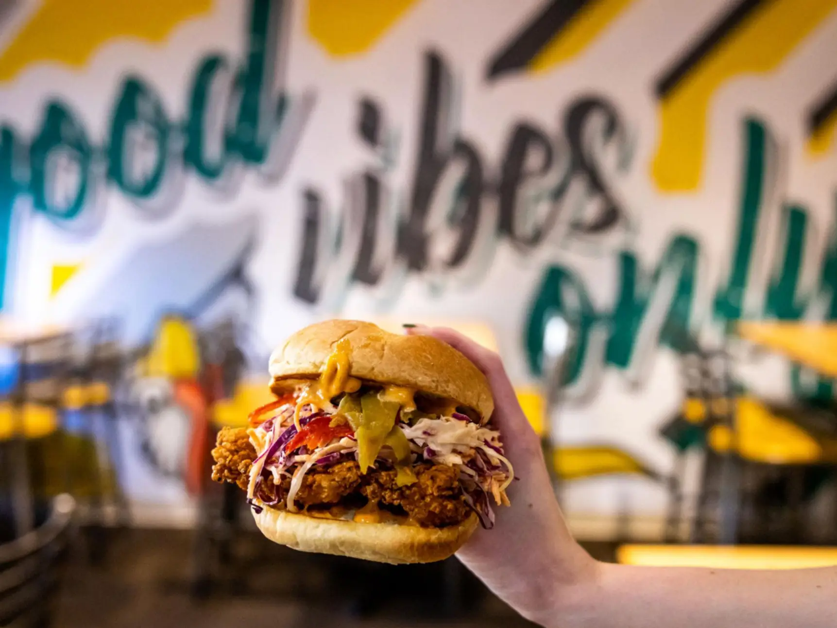 A person holding a chicken sandwich from Flip the Bird restaurant in Beverly, Massachusetts.