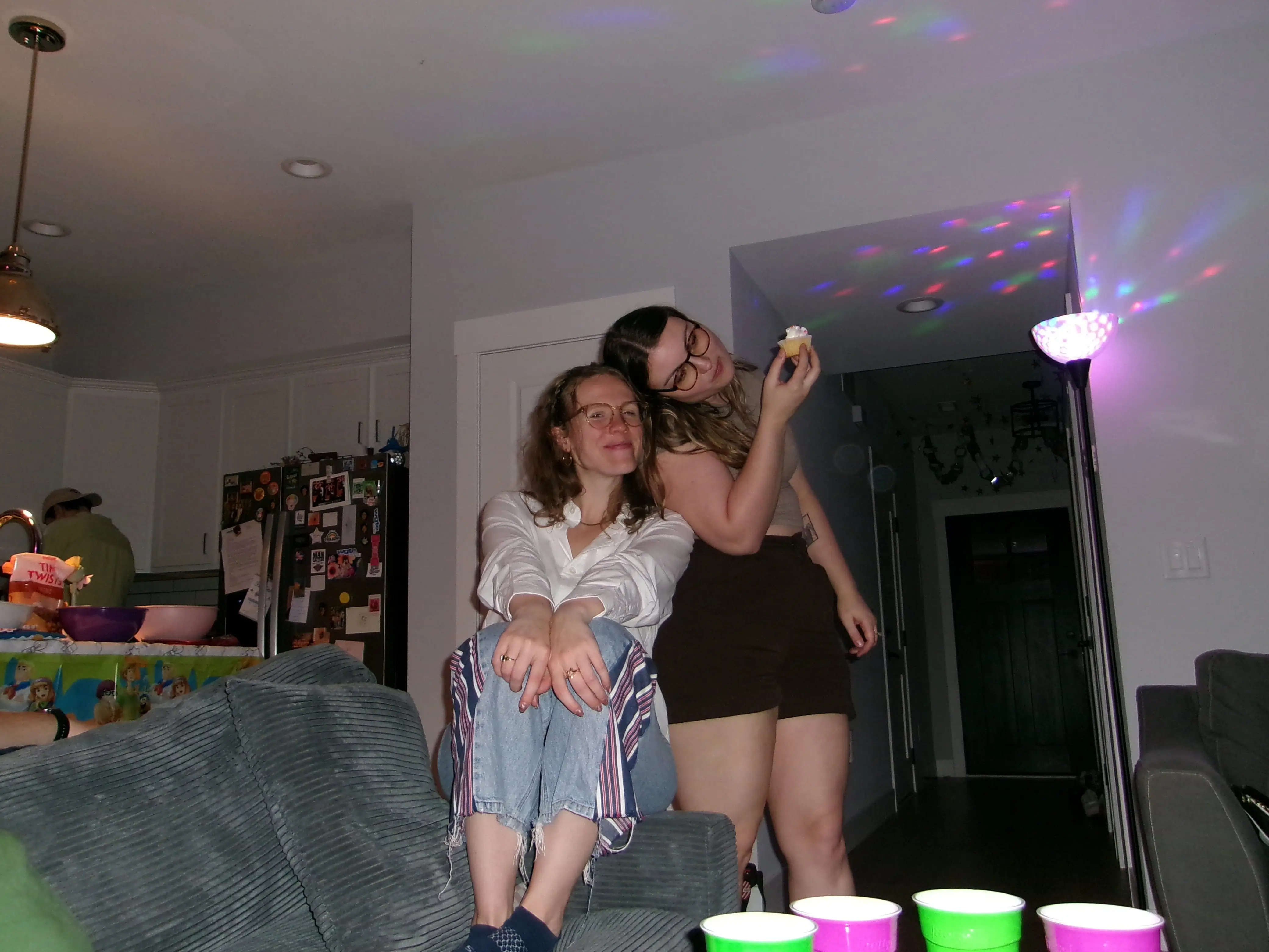 The writer is sitting on the couch next to her girlfriend in their apartment.
