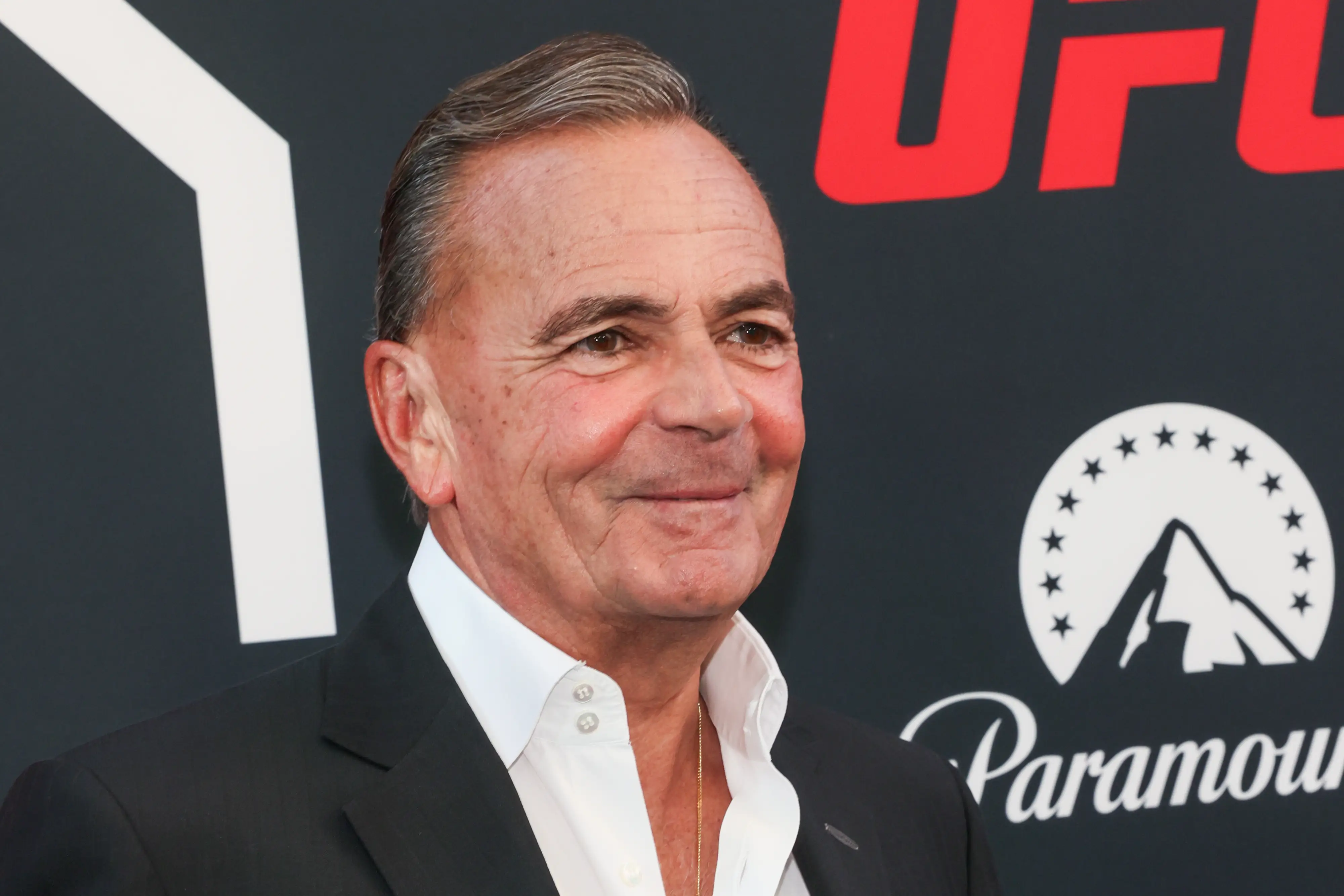 Rick Caruso stands before a black event backdrop with UFC and Paramount logos.