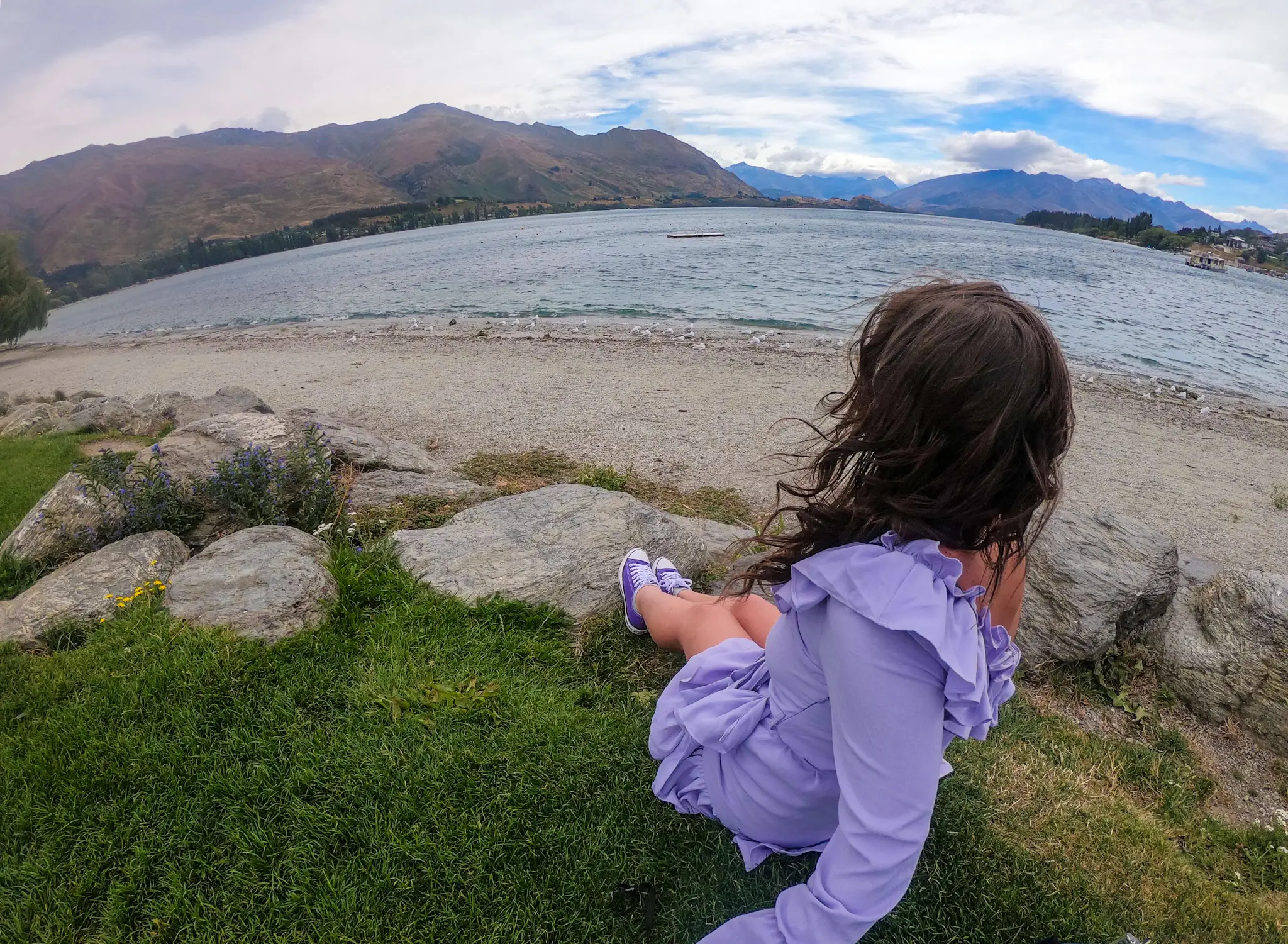 The writer posing at Wanaka Lake in New Zealand.