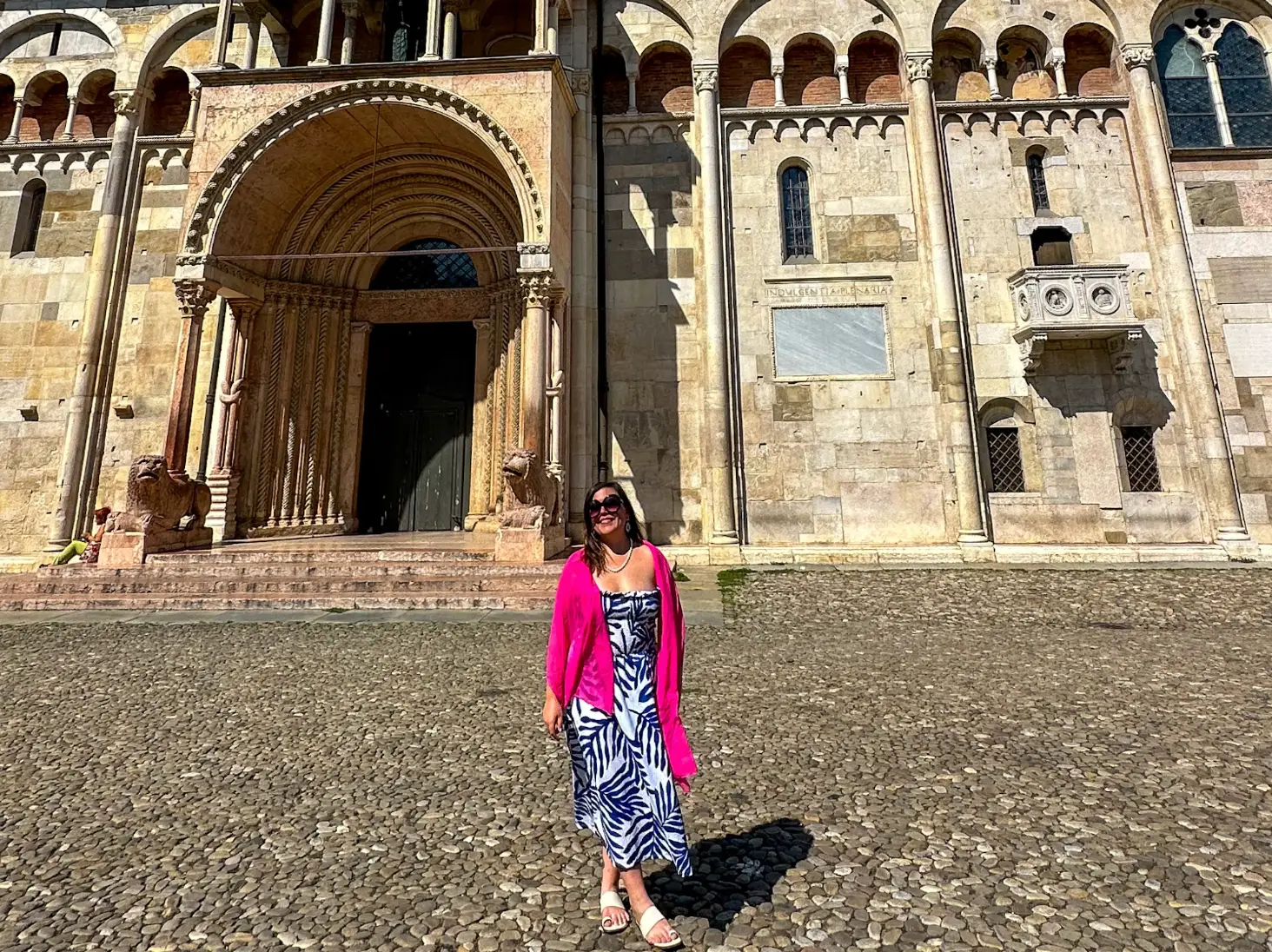 The writer standing in front of an ornate, historic building in Modena, Italy.