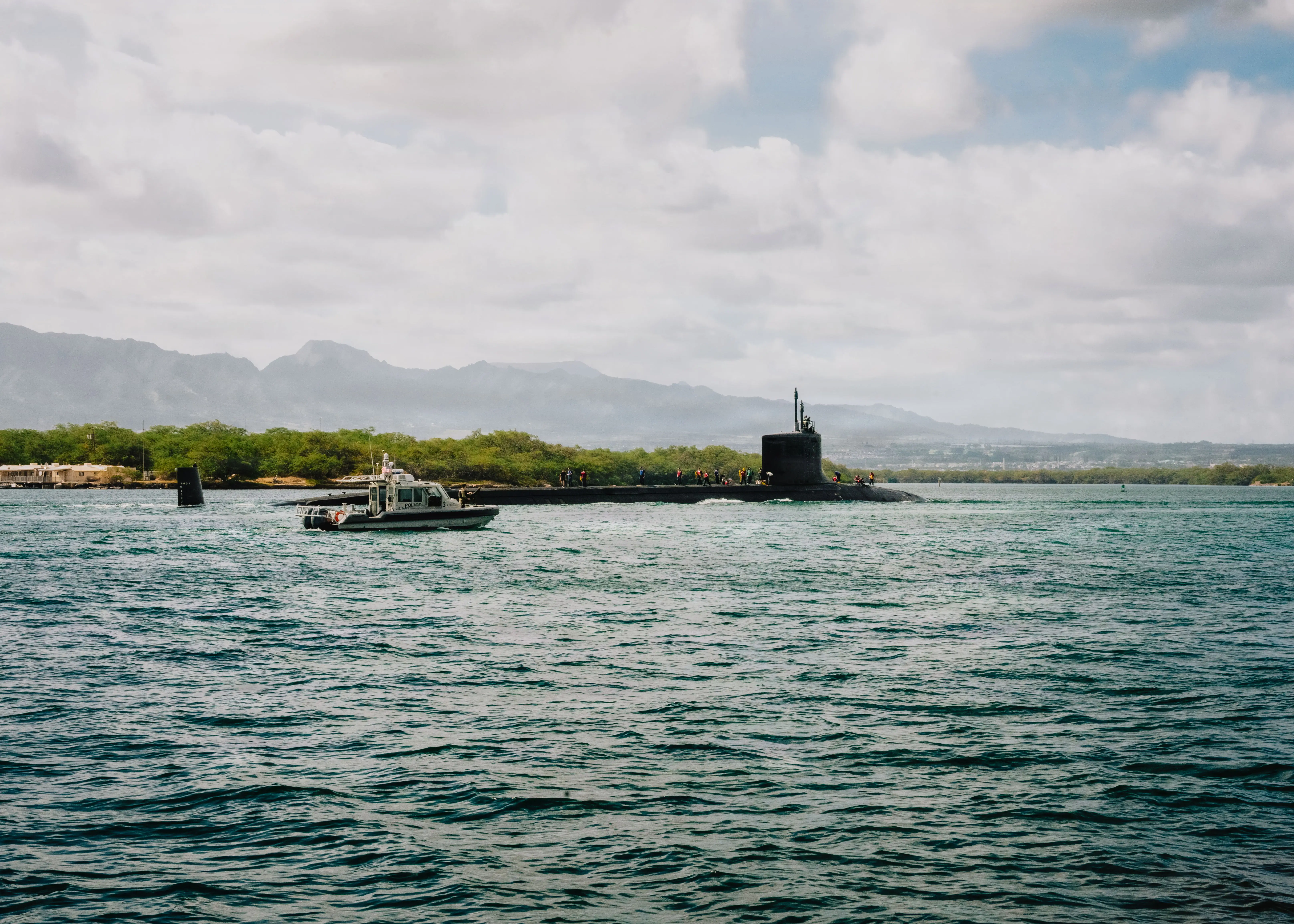 Virginia-class fast attack submarine USS Colorado sails through dark blue waters in Hawaii.
