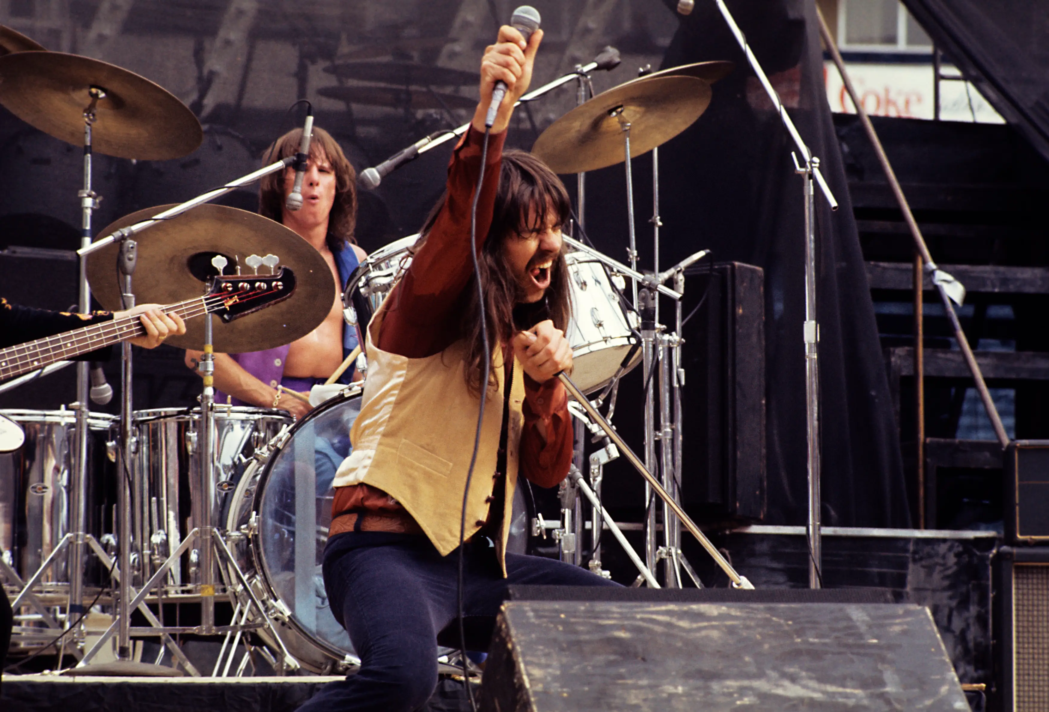 Bob Seger poses onstage with a microphone during an outdoor concert.