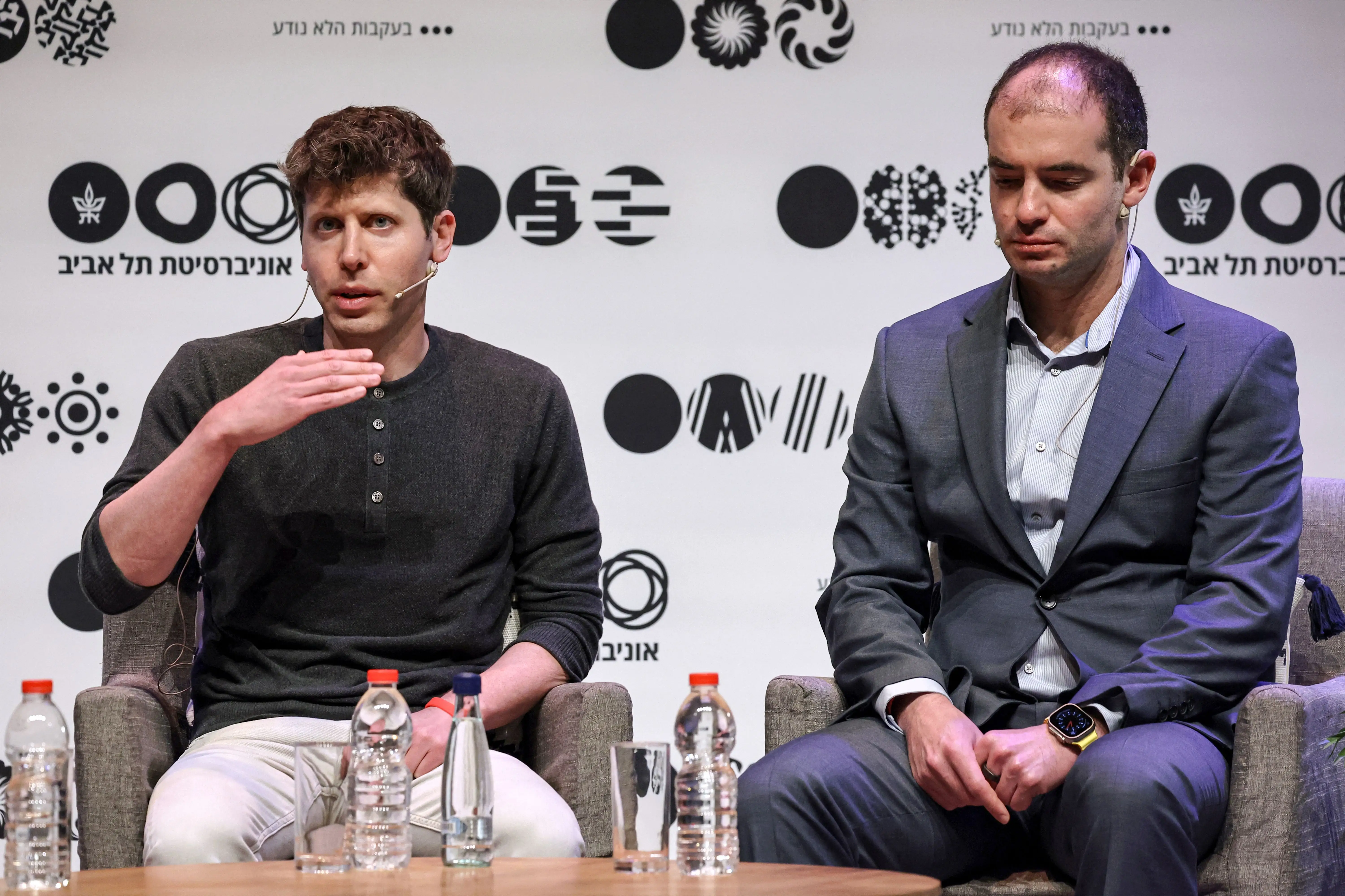 Sam Altman and Ilya Sutskever speak during an event