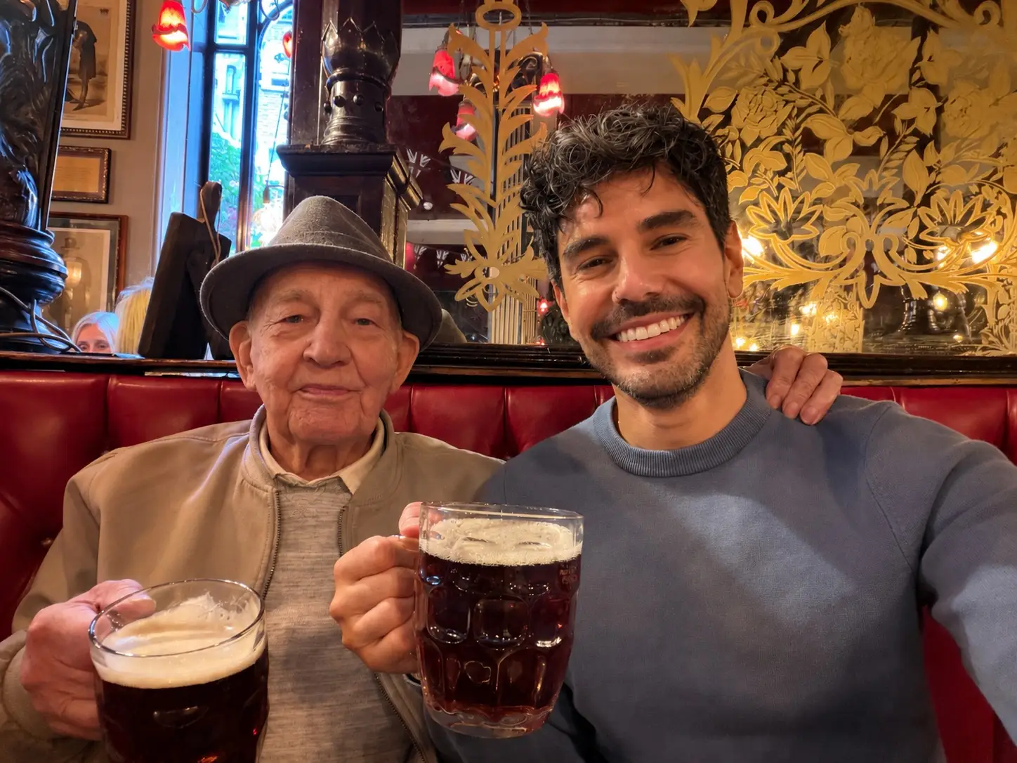 Sean and his great uncle hold pints of beer in a pub.