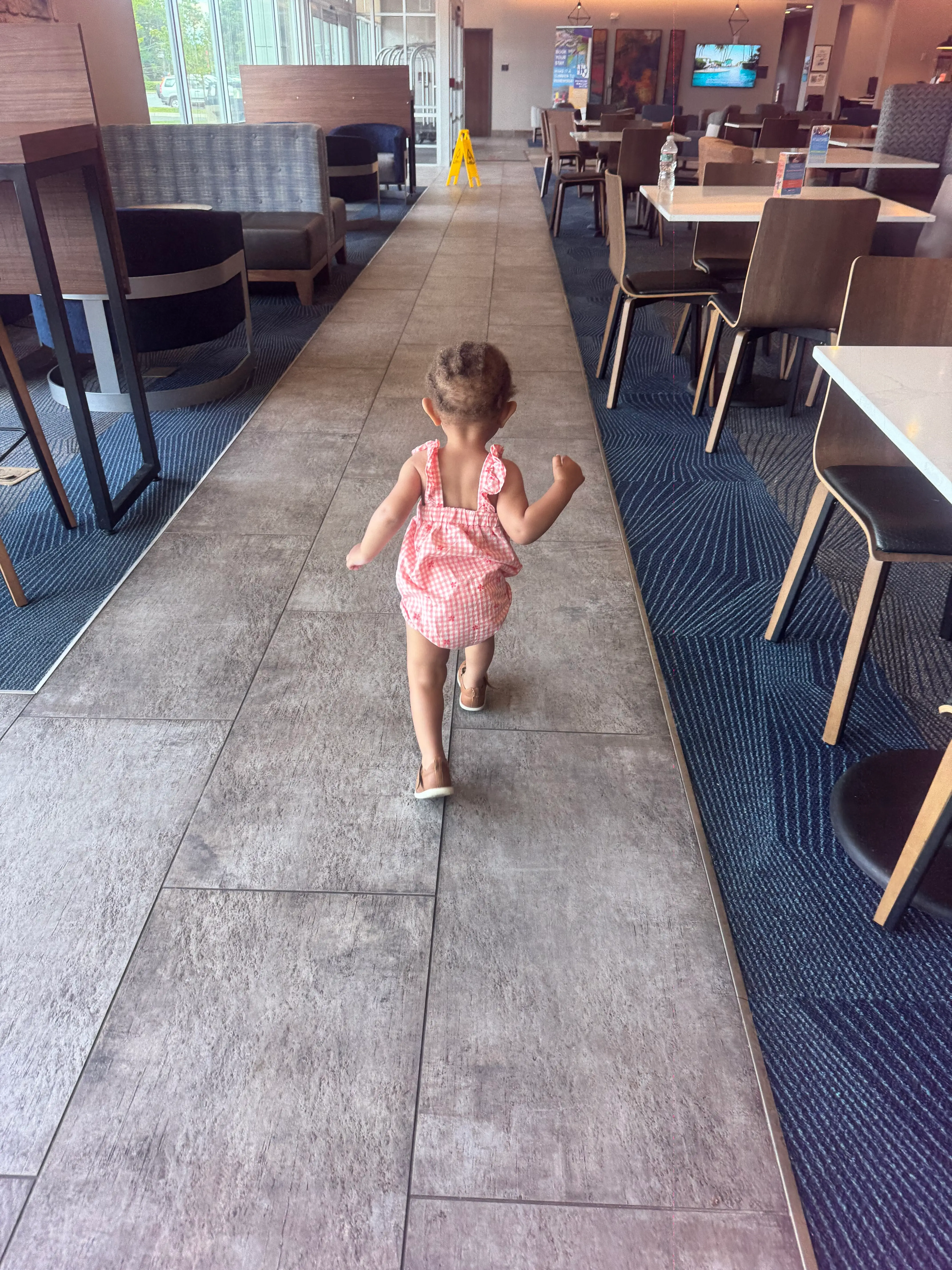 toddler running through seating area in hotel