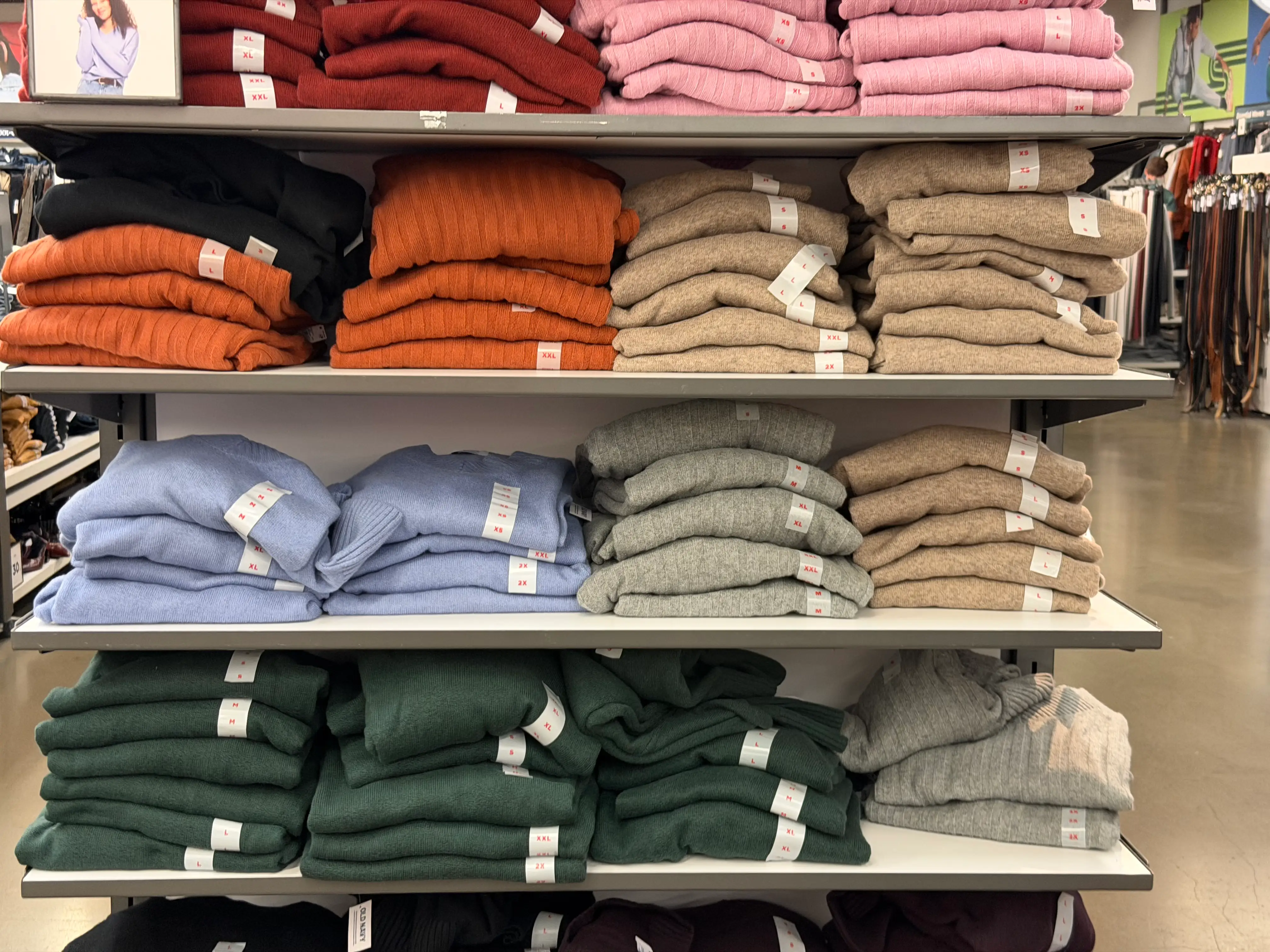 Rows of colorful sweaters on shelves.