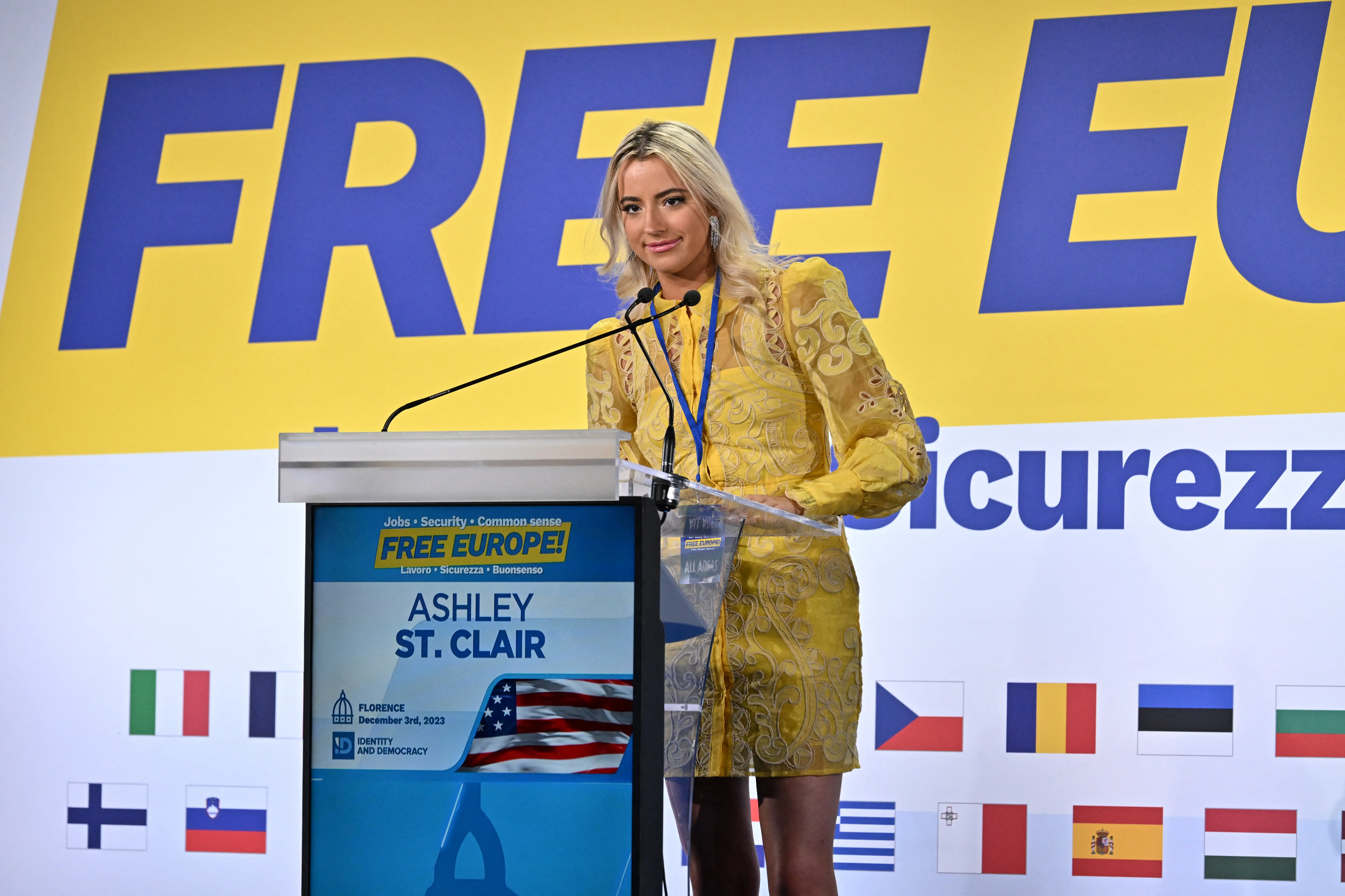 Ahsley St. Clair in a yello dress at a podium