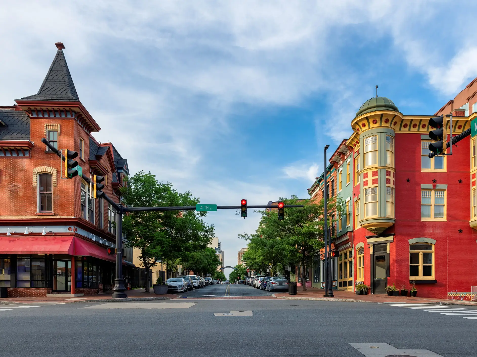 Historic brick storefronts line a quiet intersection with traffic lights and a visible 4TH street sign.