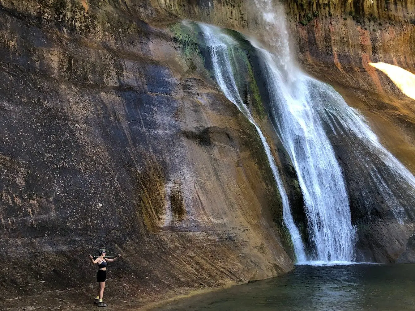 The writer is standing at Lower Calf Creek Falls in Grand Staircase-Escalante National Monument in Utah.