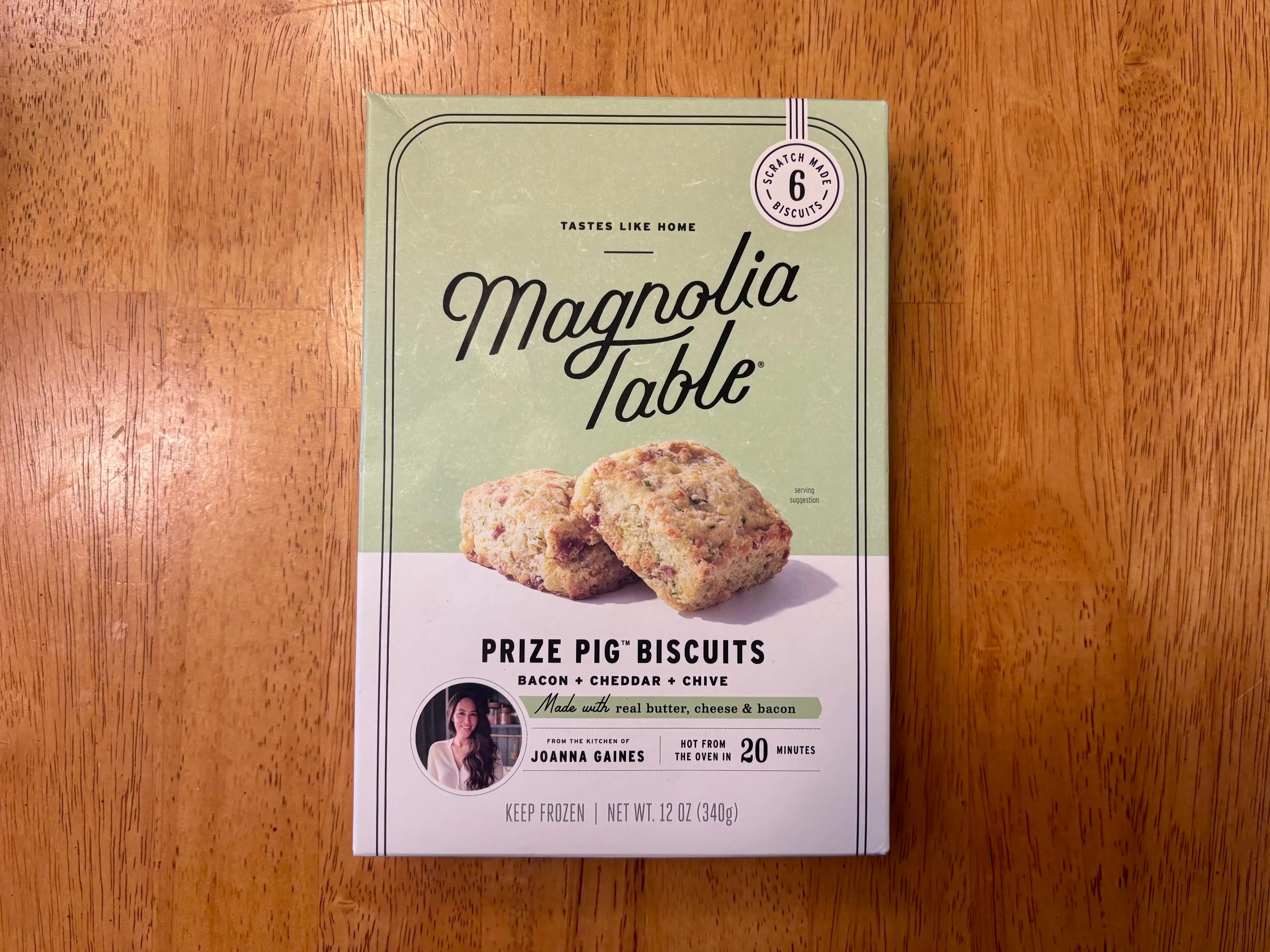 Magnolia Table Prize Pig biscuits box sits on a wooden tabletop.