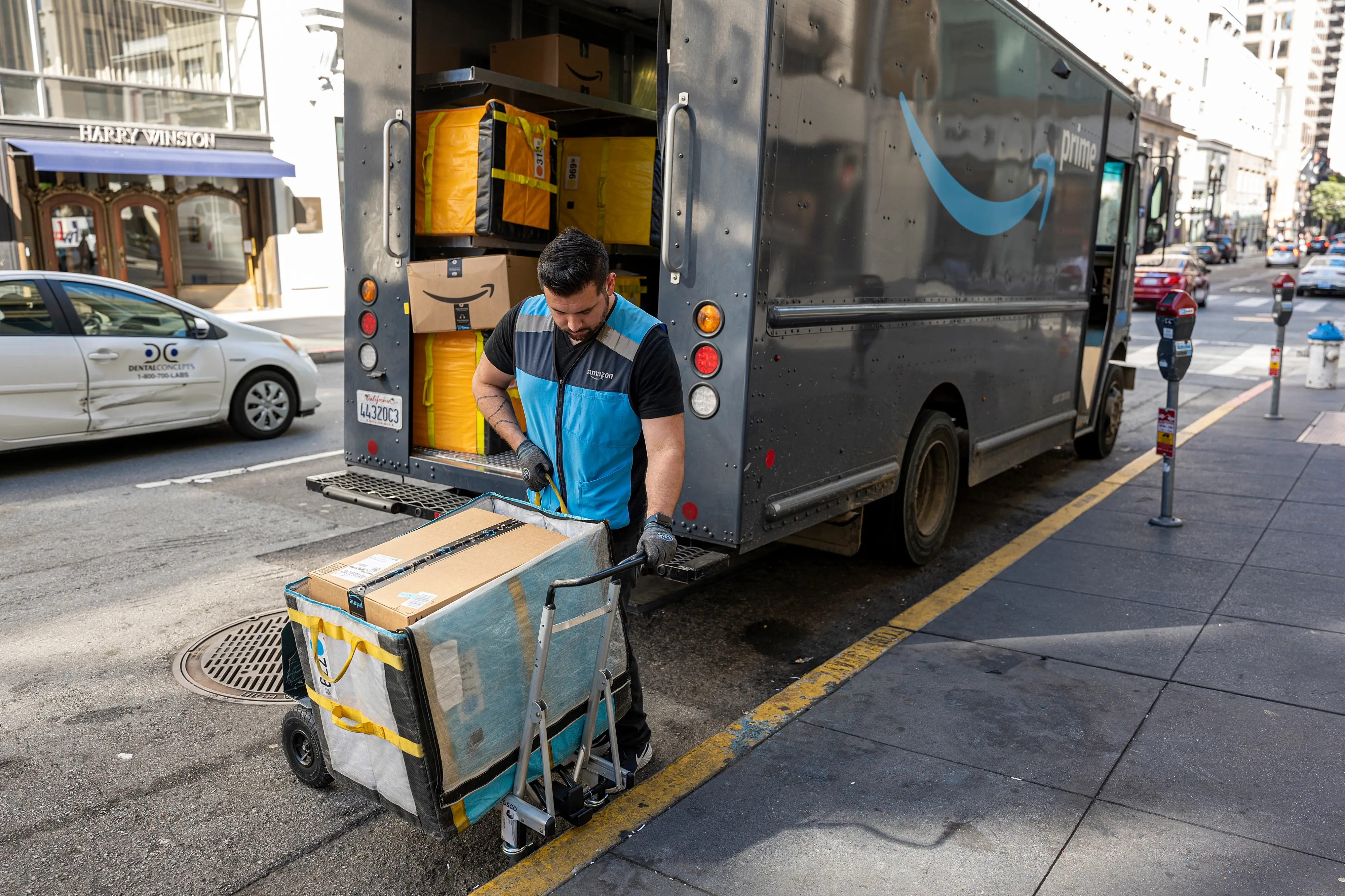 A worker delivers Amazon packages in San Francisco, on Wednesday, Oct. 5, 2022.
