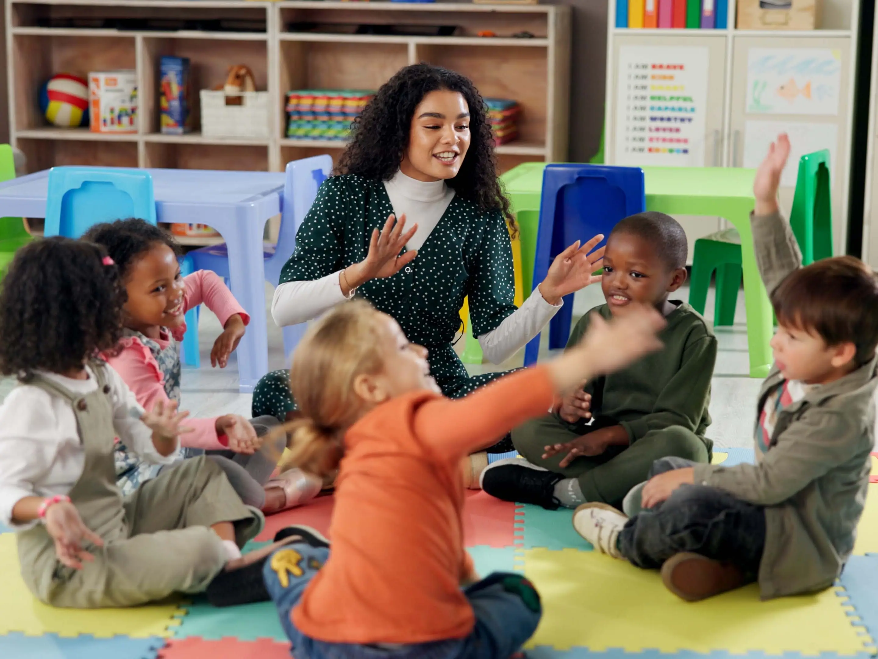 Singing, students and teacher with children in classroom for education, nursery rhyme and creative. Growth, kindergarten and academy with woman and kids at school for youth and child development stock photo