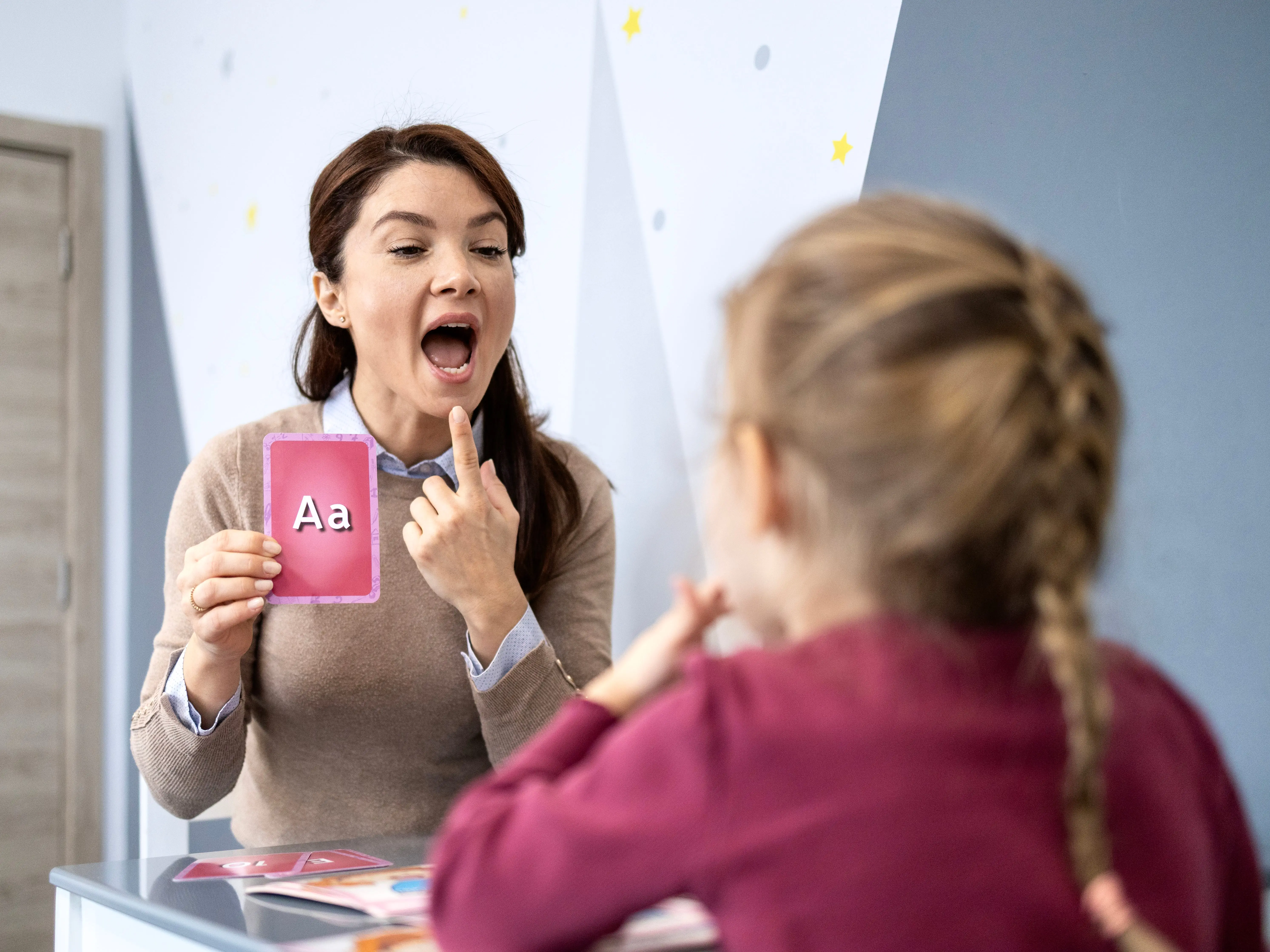 Speech therapist helping child during speech therapy session. Speech disability. stock photo