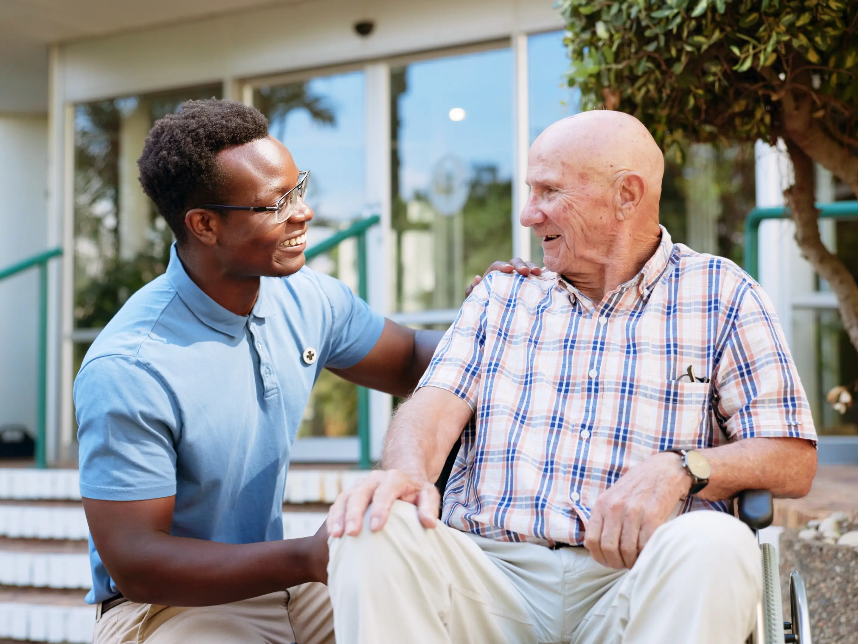 Nurse, smile and healthcare with old man in wheelchair for rehabilitation, osteoarthritis and physiotherapy. Medical, retirement and caregiver with person with a disability for trust and elderly care stock photo