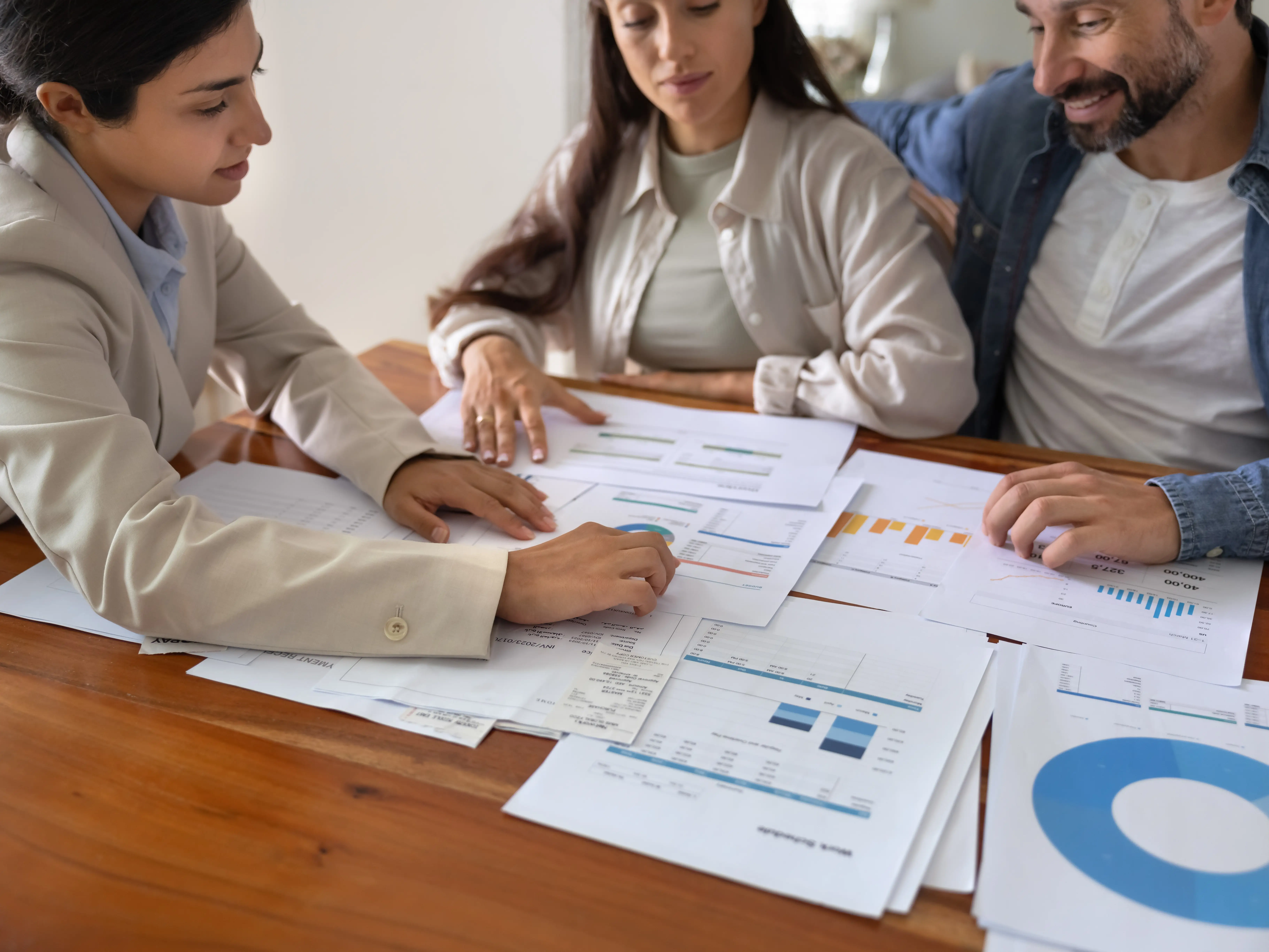 Advisor reviewing real estate charts with married couple stock photo