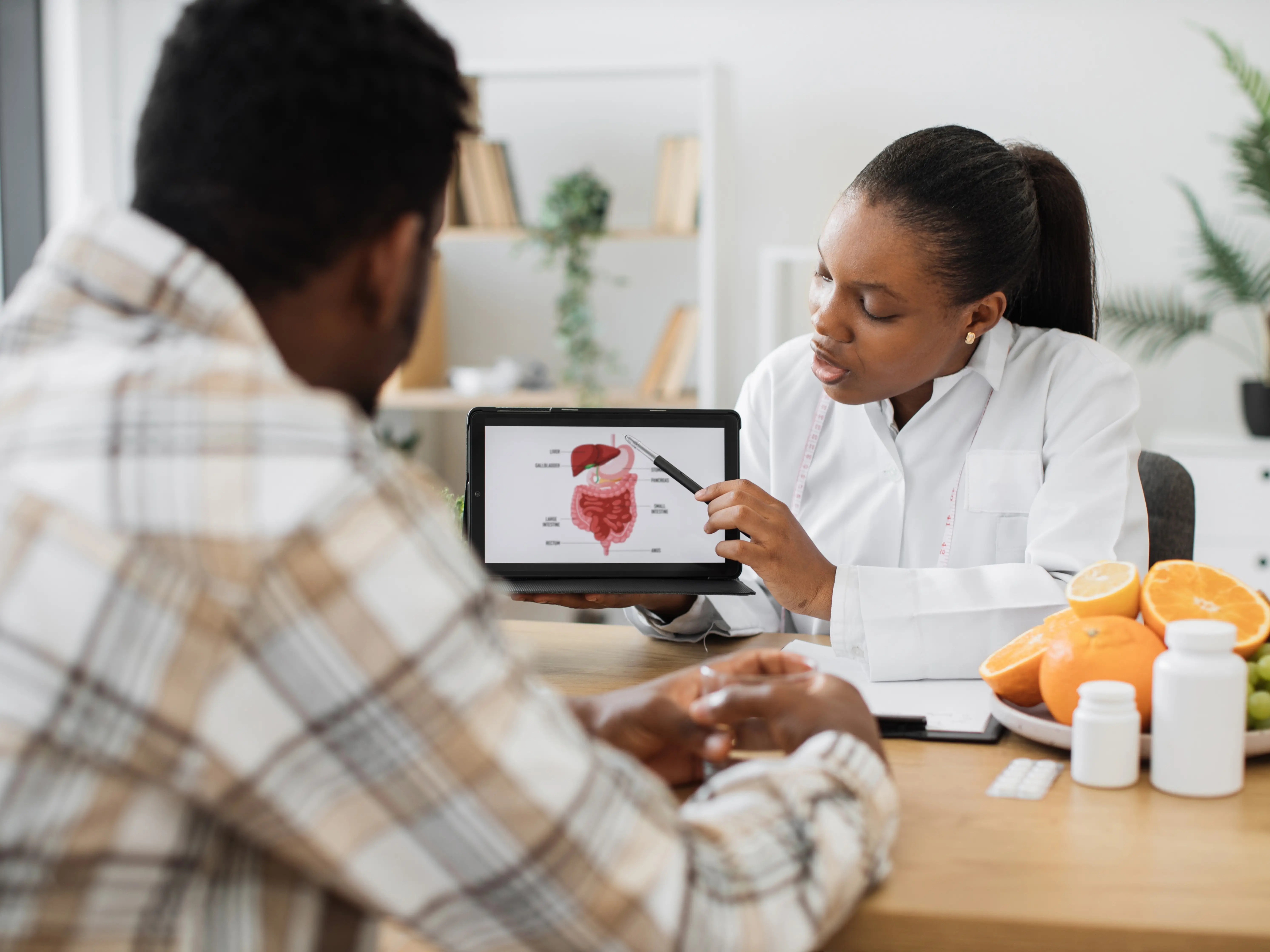 Woman holding tablet with GI tract while counseling client stock photo