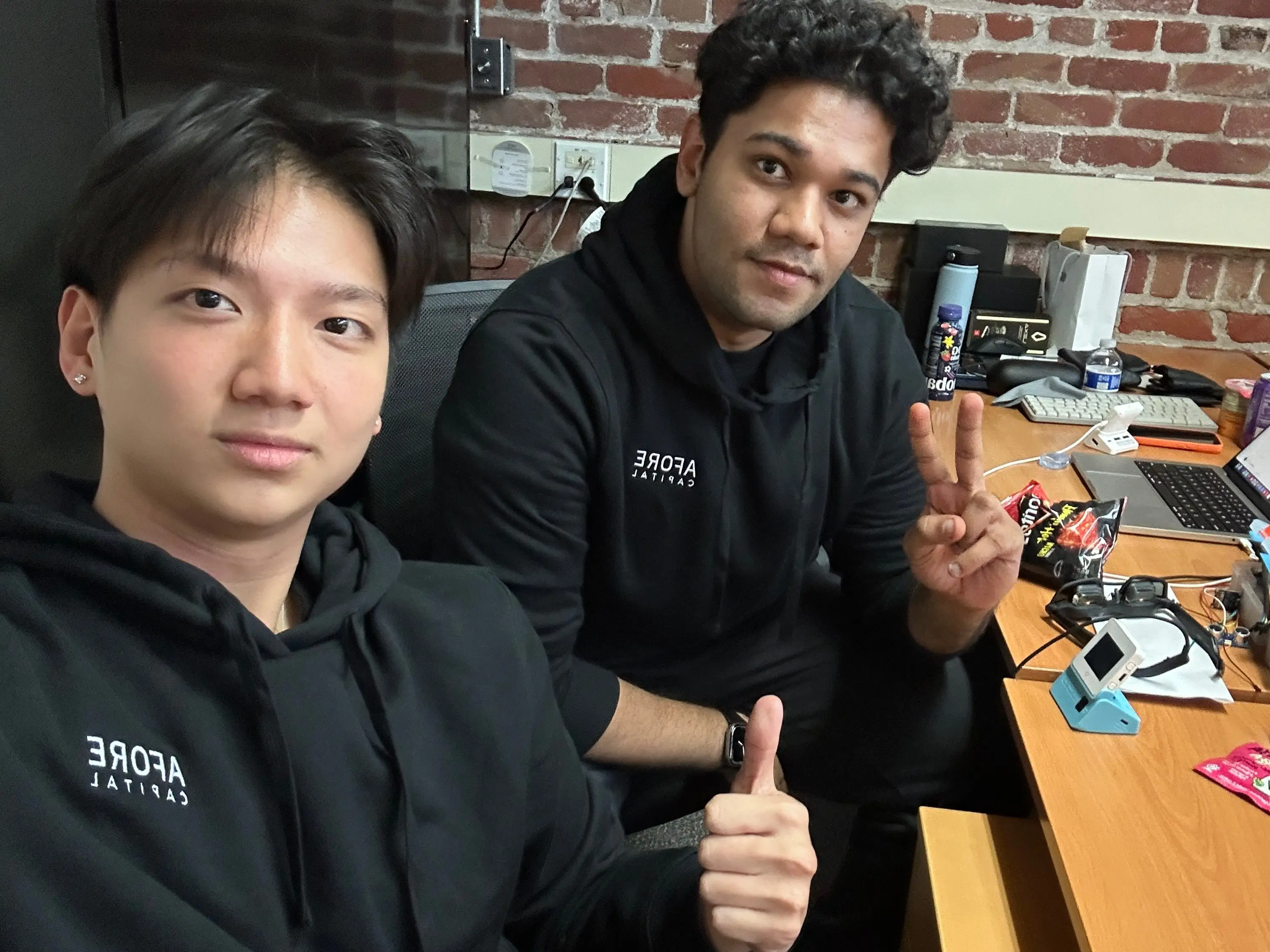 Two founders of a startup are working at a desk.