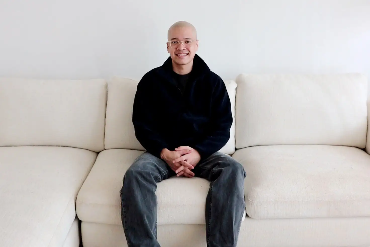 A man sitting on a white couch.