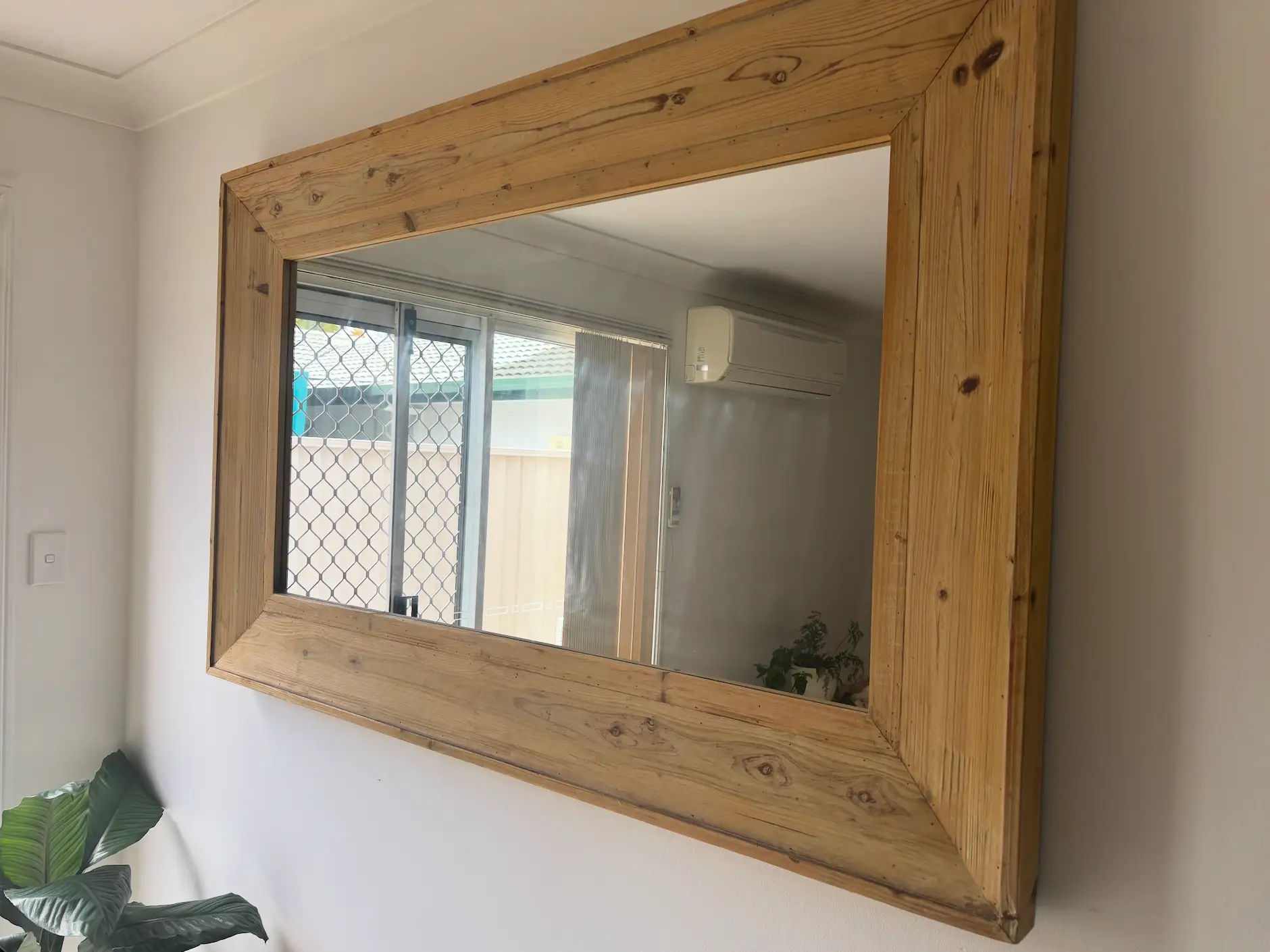 mirror hanging on a wall with wide wooden frame