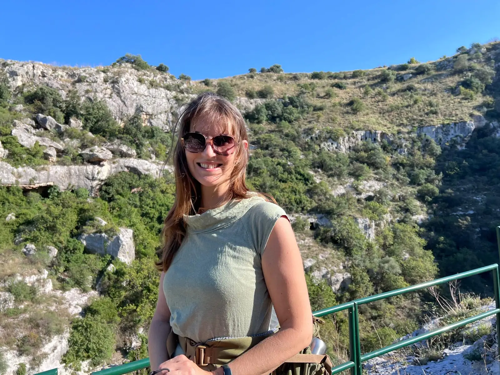 The writer stands on a ledge in Pantalica in Italy.