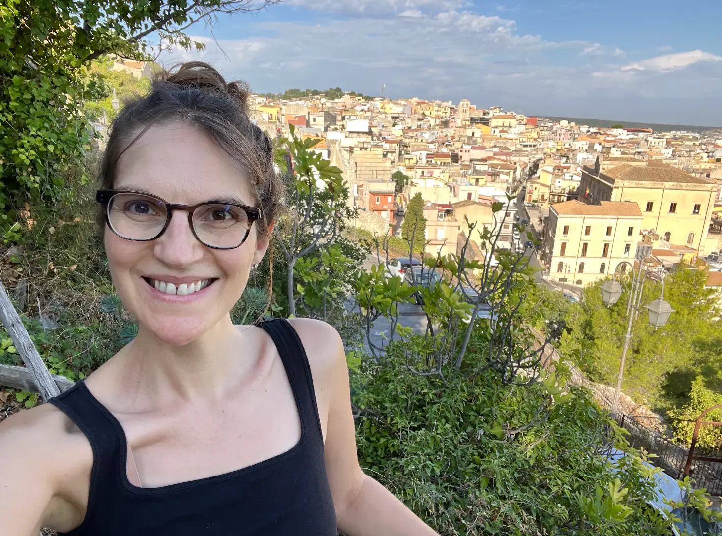 The writer poses for a selfie, with her village's historic center in the background.