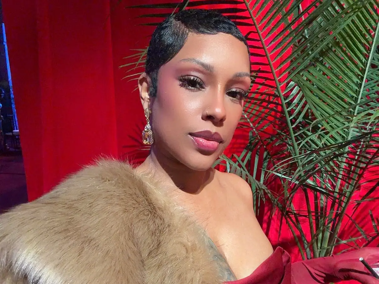 A woman in a red evening gown taking a selfie.