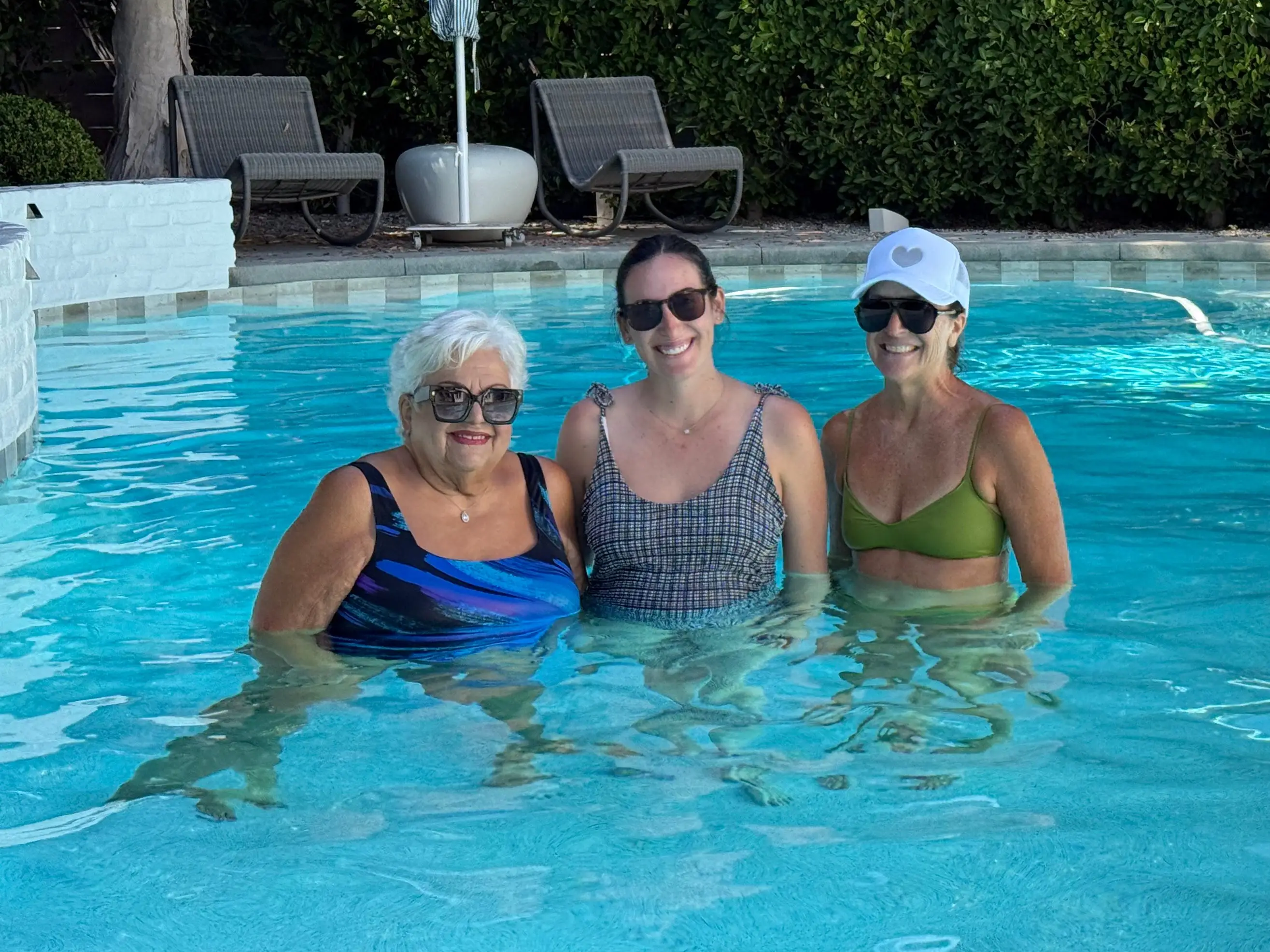 Blake, her mom, and her grandmother standing in a pool.