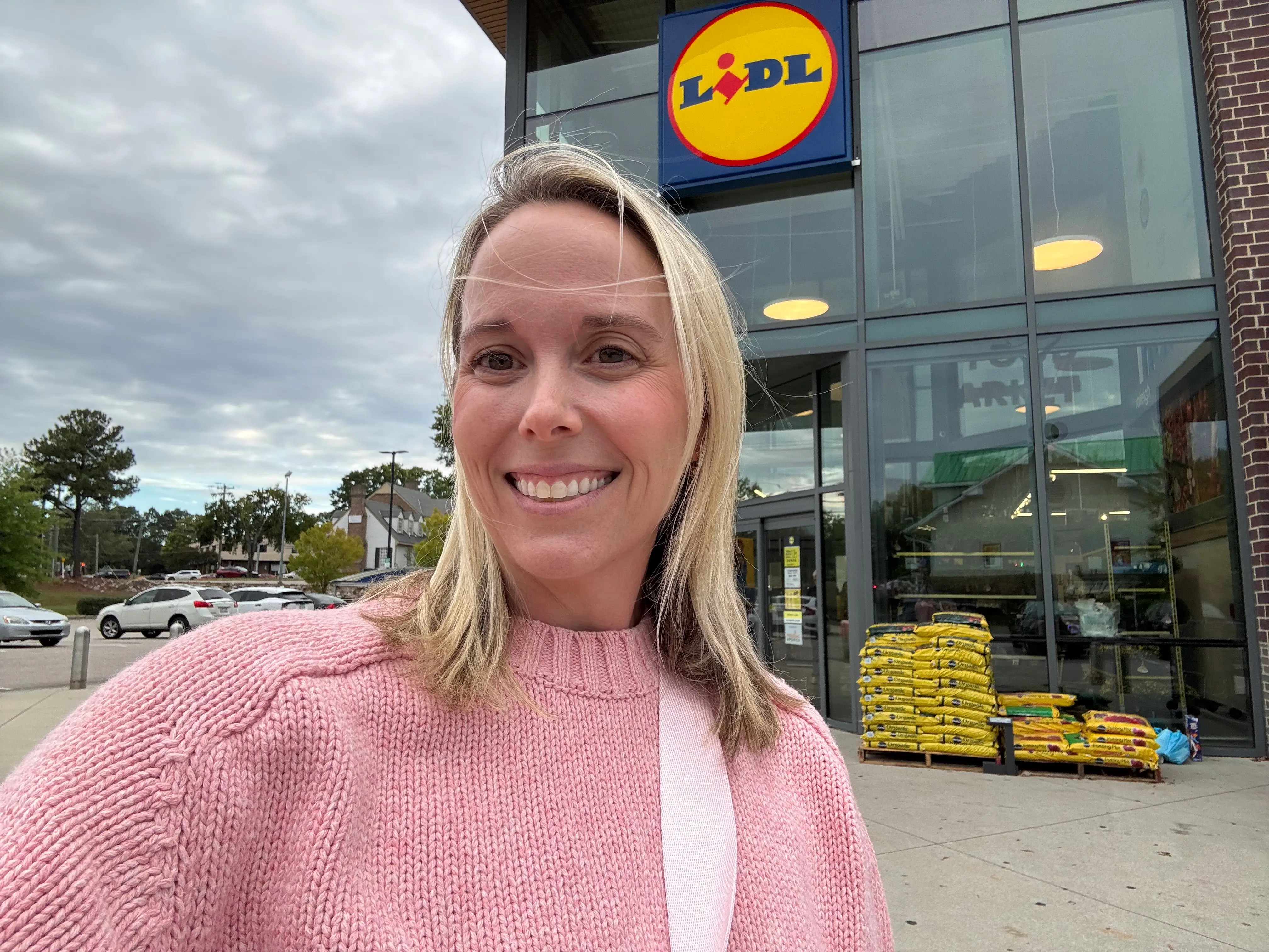Woman smiling in front of a Lidl exterior