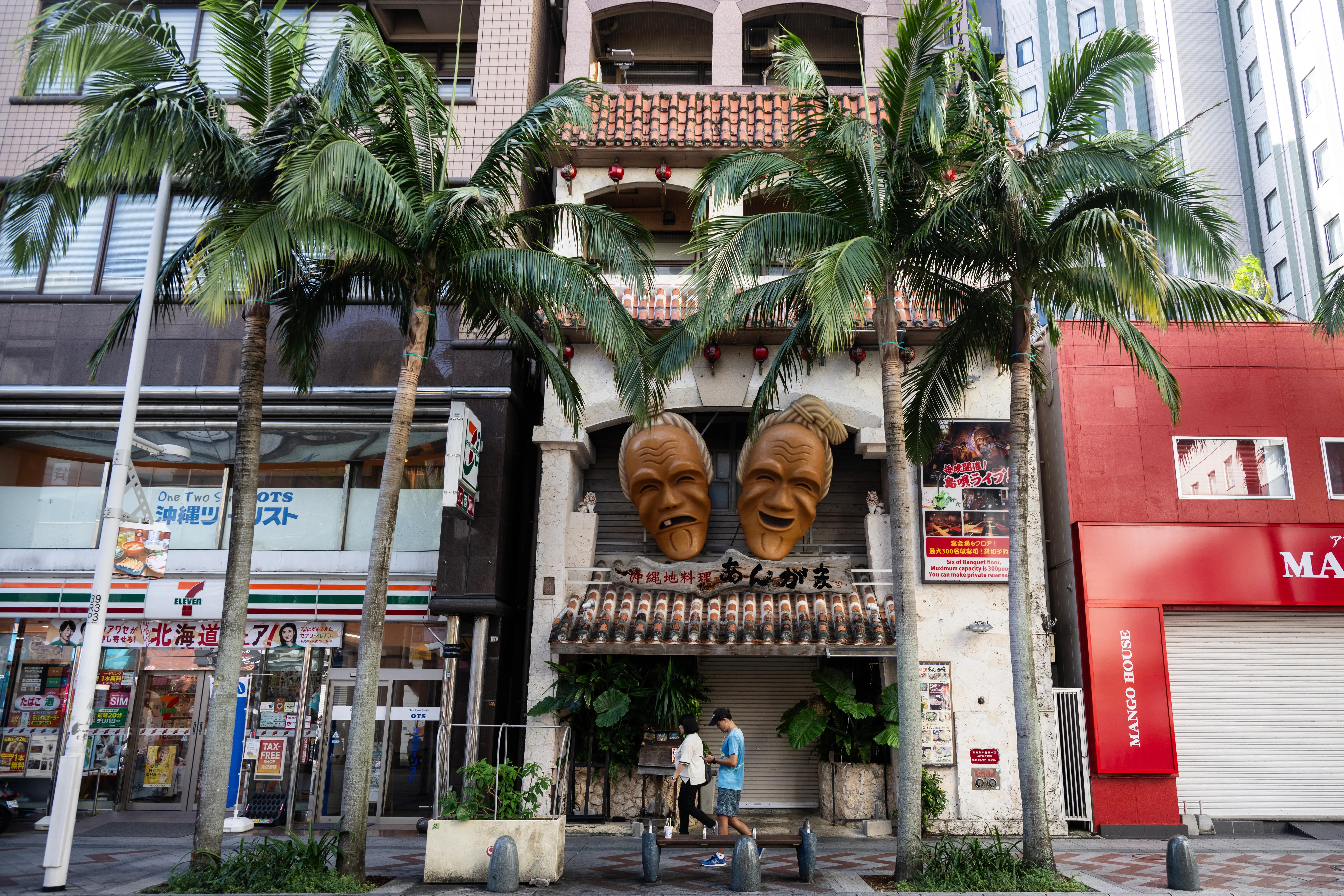 Tourists pass shops in downtown Naha, Okinawa prefecture.