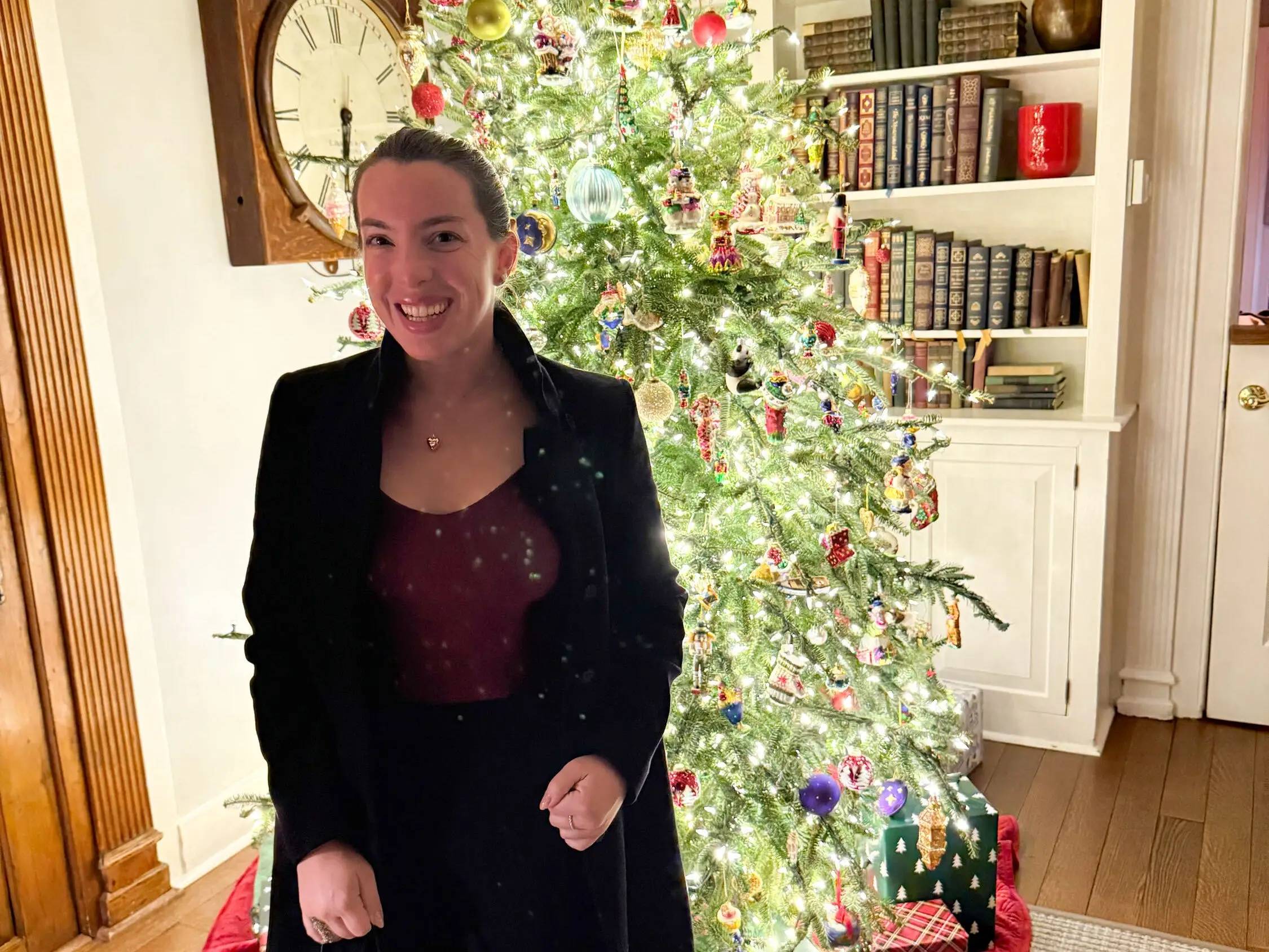 The writer is standing in front of a Christmas tree in the Hamptons.