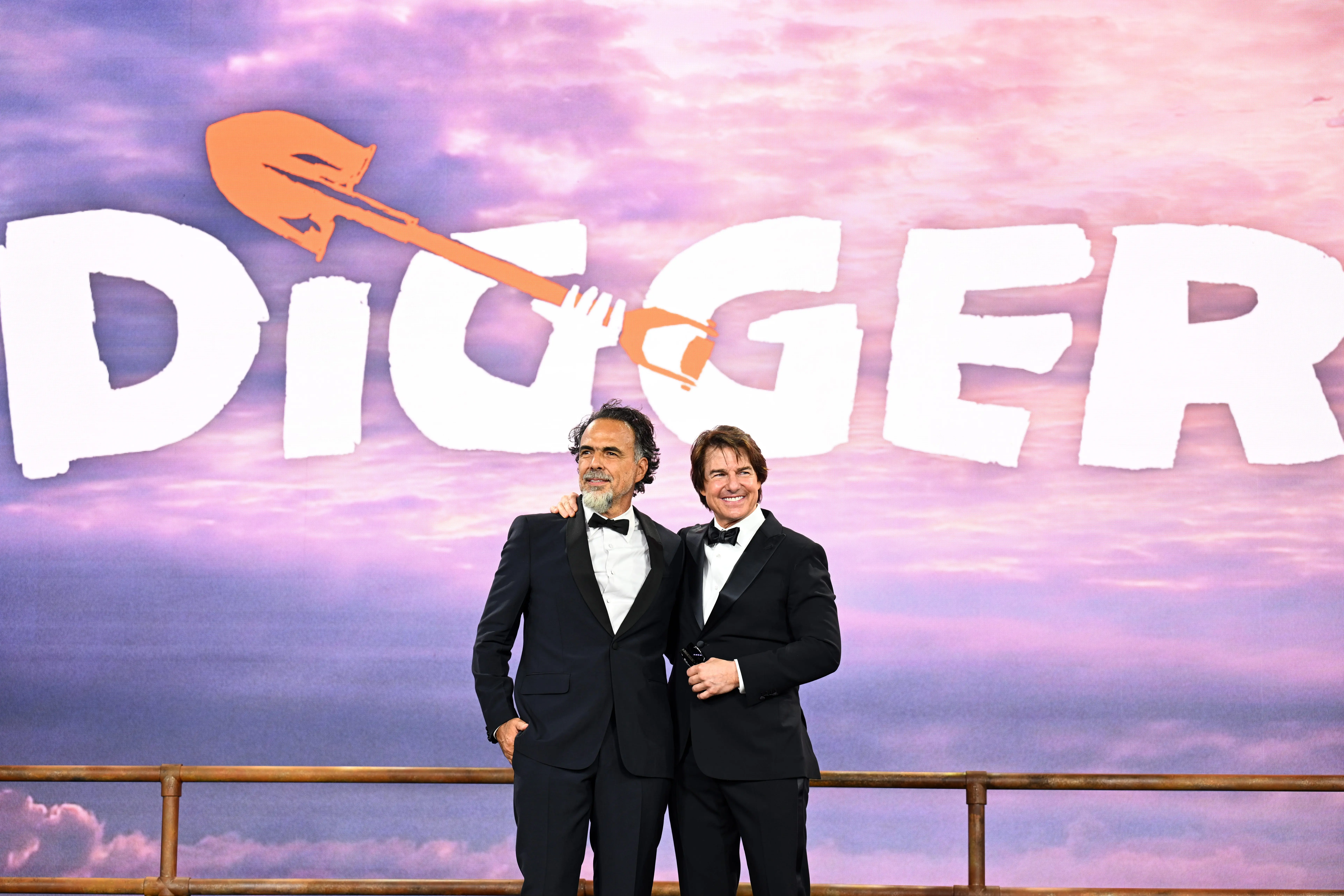 Alejandro Inarritu and Tom Cruise standing in front of a Digger sign