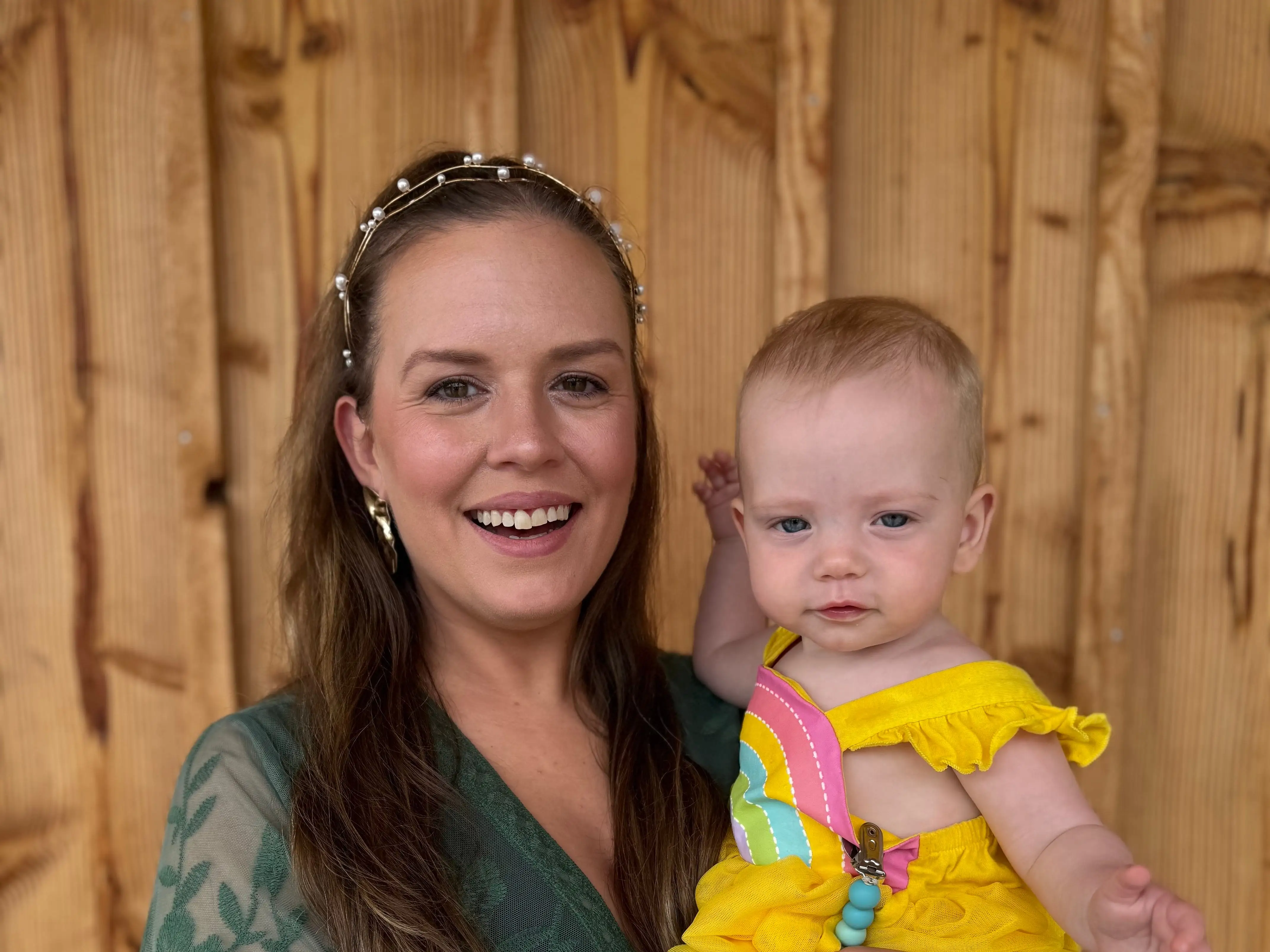 The writer wears a green dress and holds her niece.