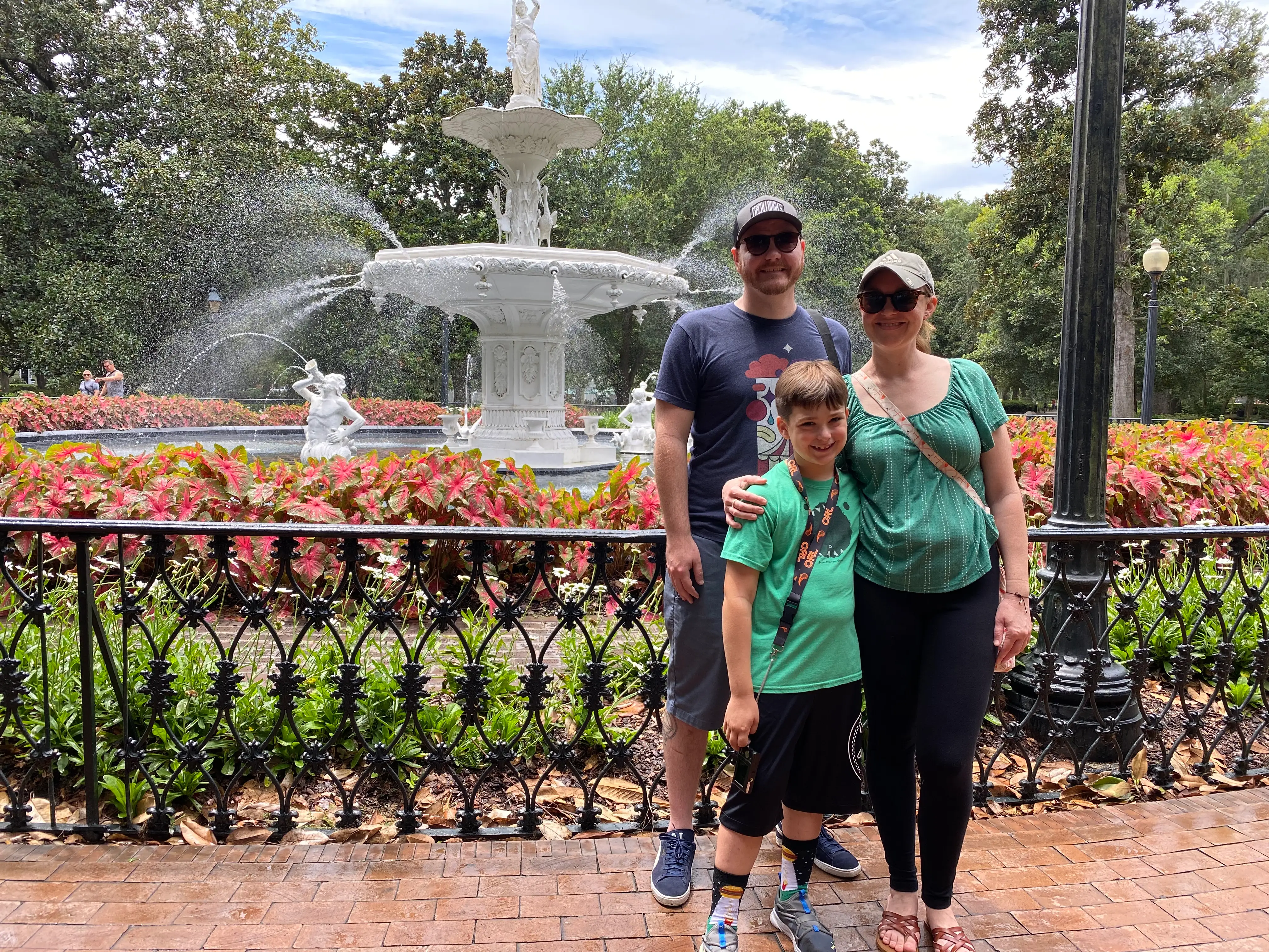 the author and her son and husband standing in front of a fountain