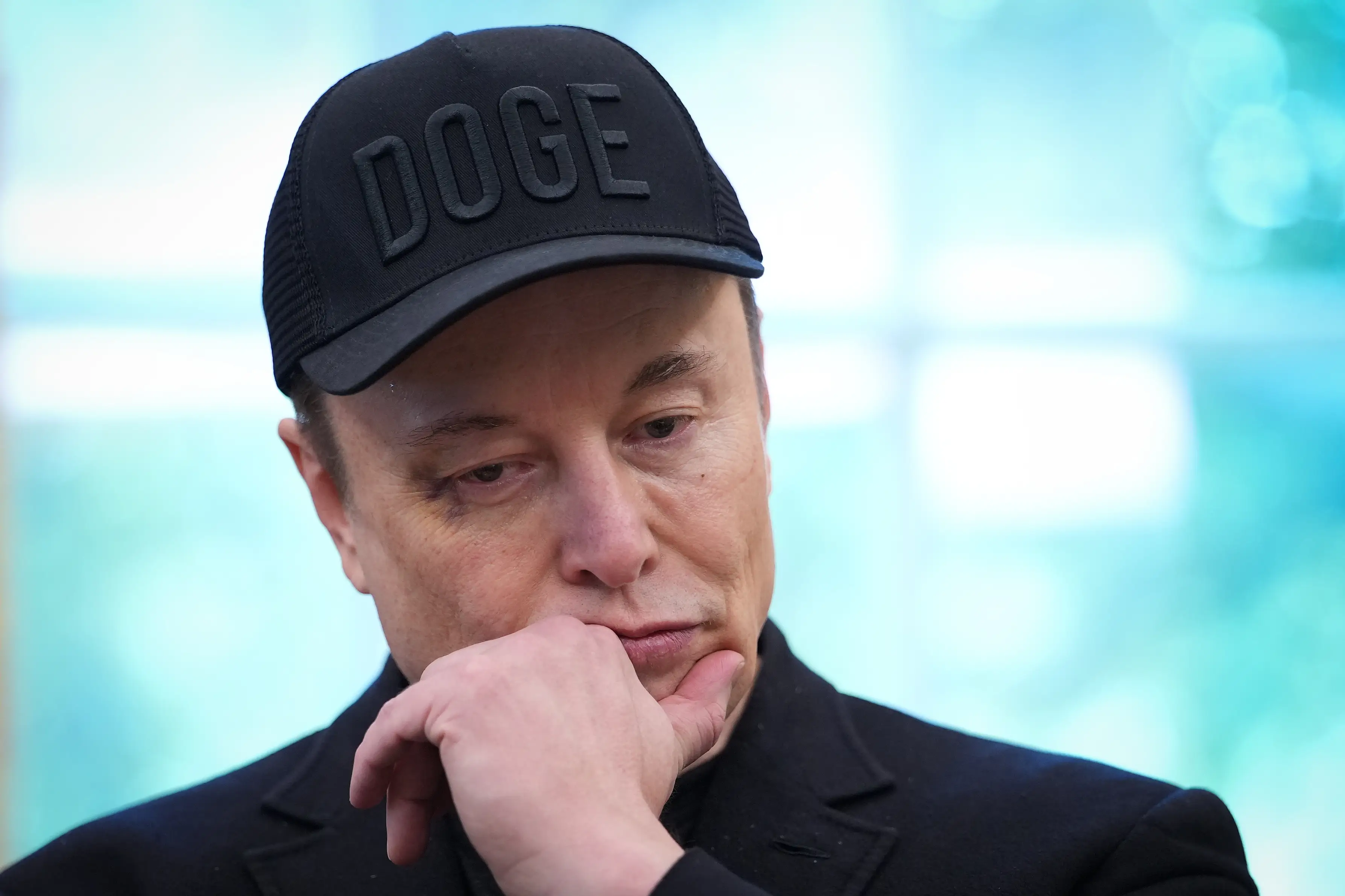 Elon Musk listens in the Oval Office