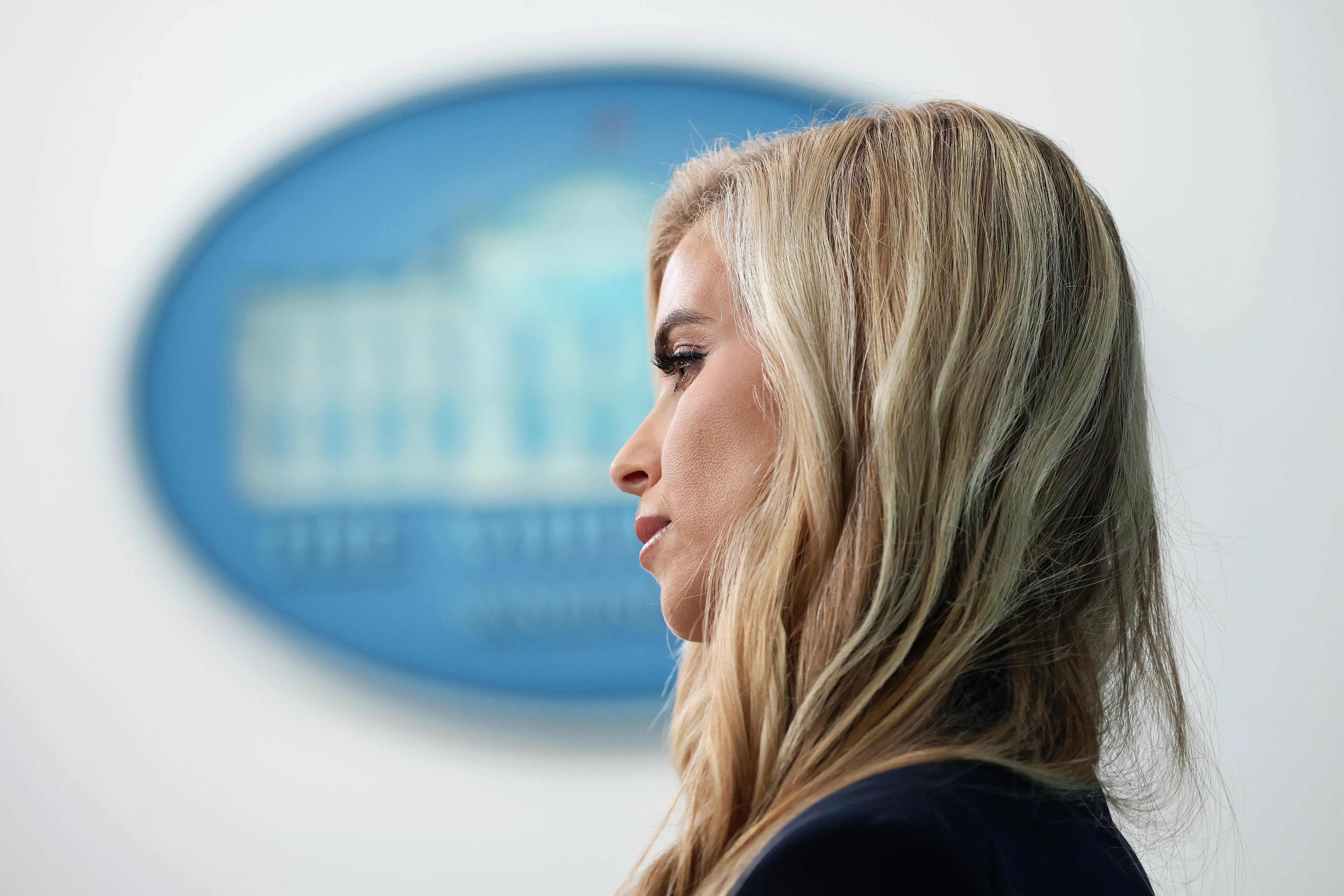 White House Press Secretary Katie Zacharia looks to the left